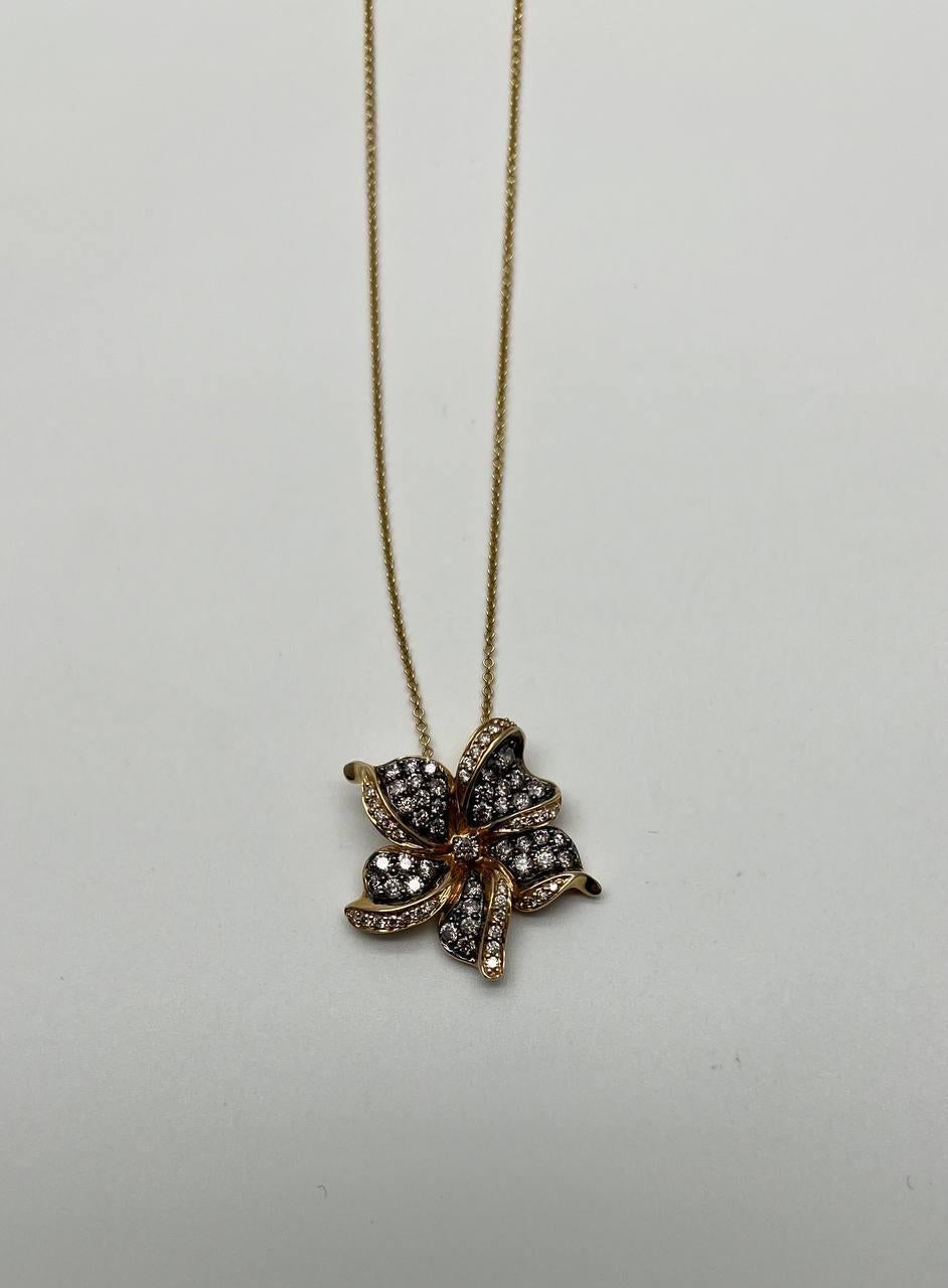 A stunning diamond flower pendant necklace.

The pendant showcases a floral design with petals encrusted in shimmering diamonds. Each petal is outlined in gold, creating a striking contrast and enhancing the brilliance of the stones. 14K Yellow