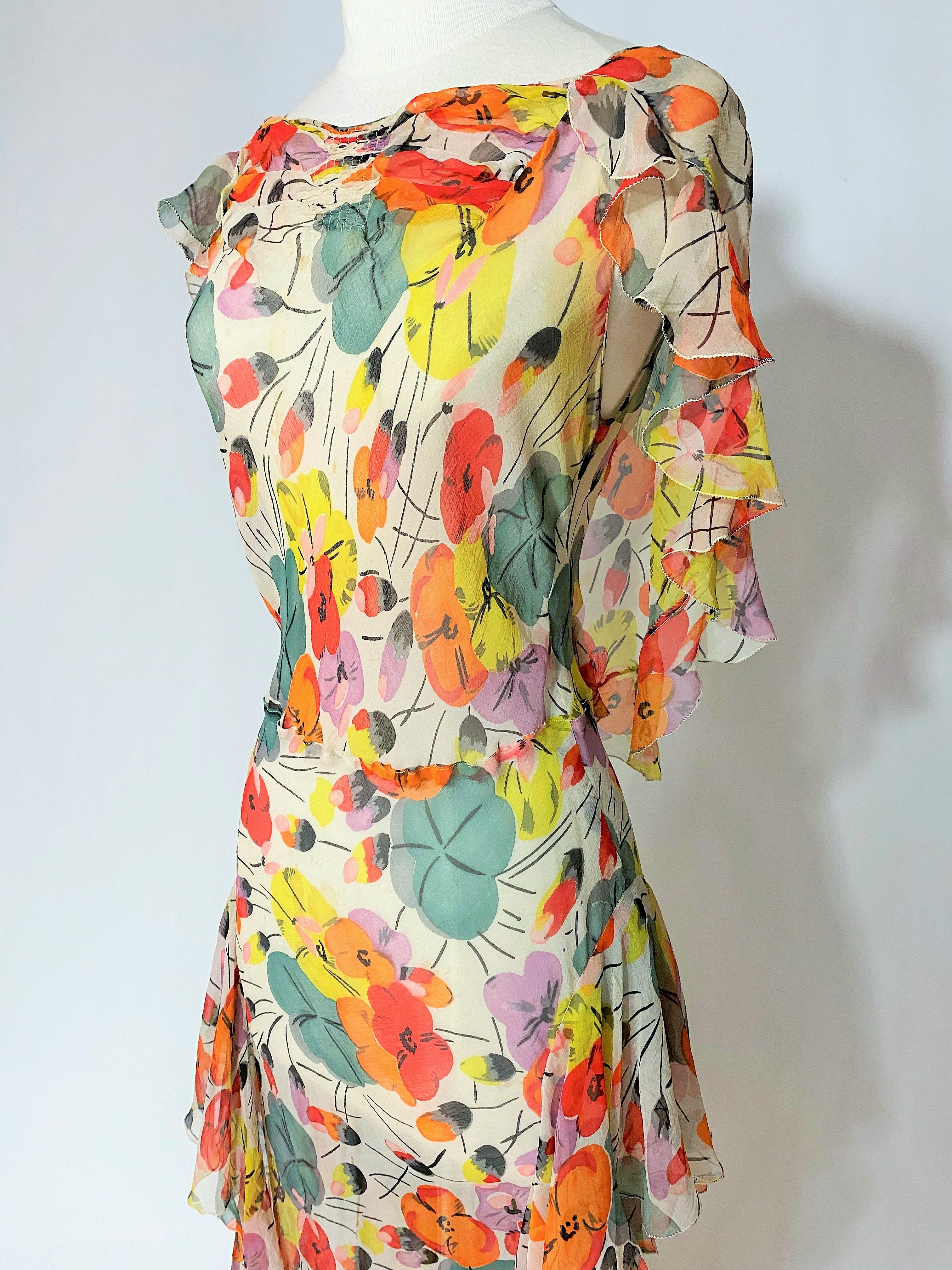 Circa 1938-1940
France

Beautiful summer long dress in silk crepe muslin printed with large polychrome flowers (poppies?) and inspired by Raoul Dufy's creations. Sleeveless sheath dress with fine pleats underlining the chest and large flounces on