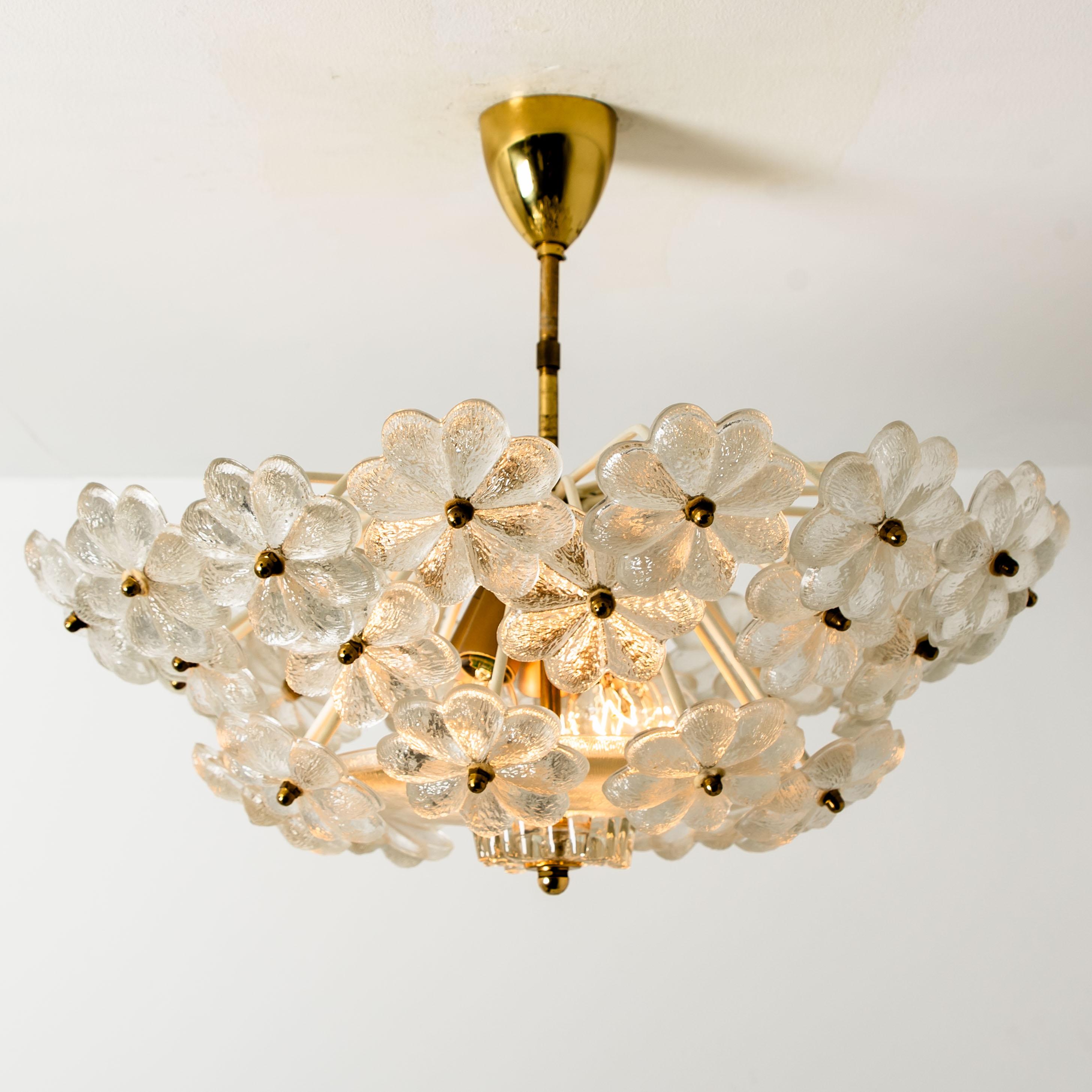 These sculptural chandelier has the design of a bouquet of textured glass flowers and are from the historical lighting company Ernst Palme.

Each clear glass flower shade has textured petals and is securely screwed in place to the white frame. The