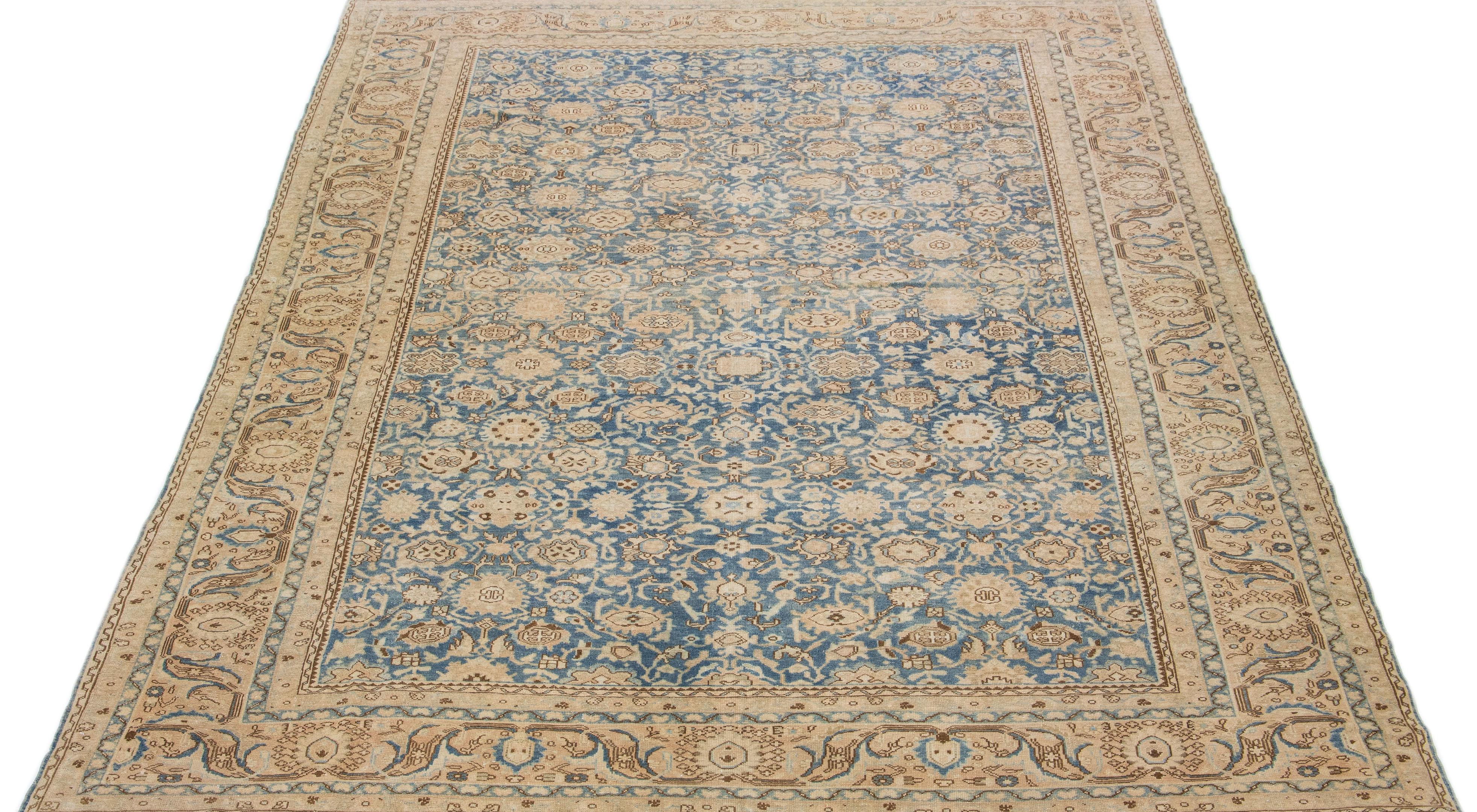 A beautiful Antique Malayer hand-knotted wool rug with a blue field. This Persian rug has beige and brown accents in an all-over rosette design.

This rug measures 10'2