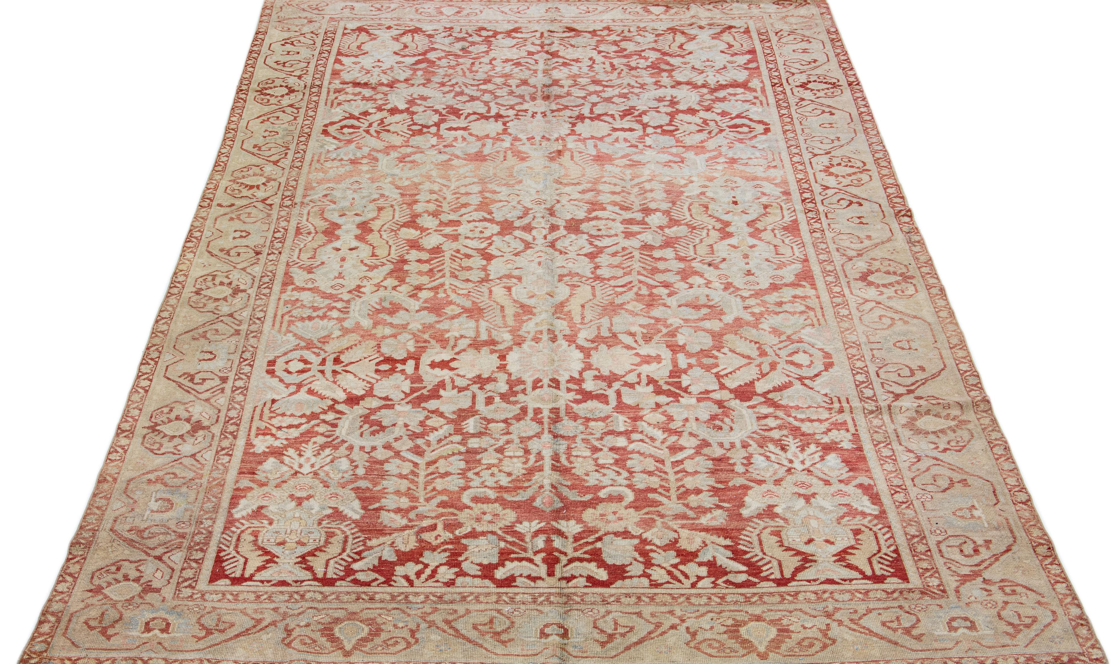 A beautiful Antique Malayer hand-knotted wool rug with a rust-red field. This Persian rug has beige and blue accents in an all-over floral design.

This rug measures 8'2