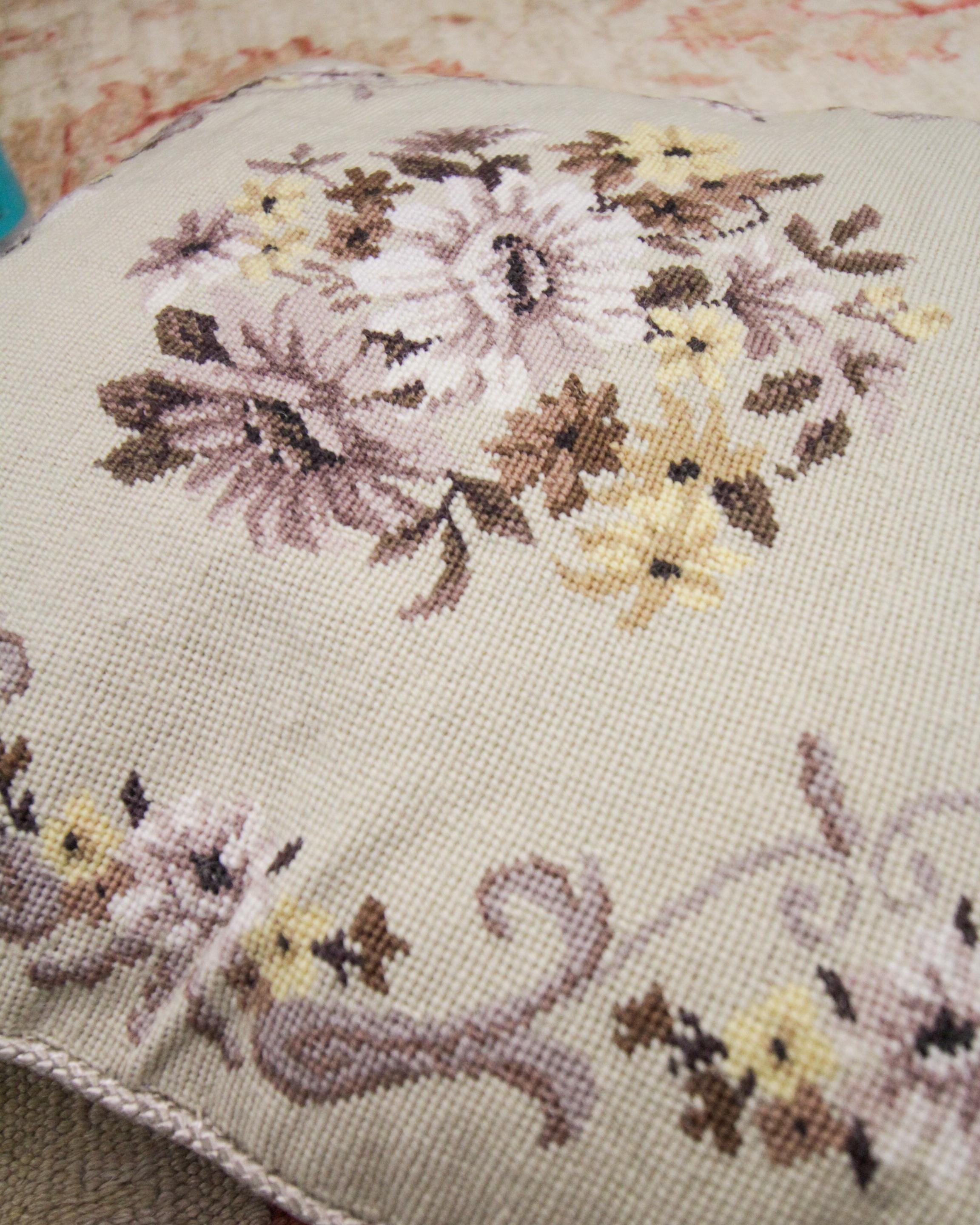 This beautifully unique floral cushion cover has been woven by hand with a floral design, woven in accents of purple, blue, orange and grey on a subtle cream background. The colour and design of this elegant hand-embroidered cushion make it the