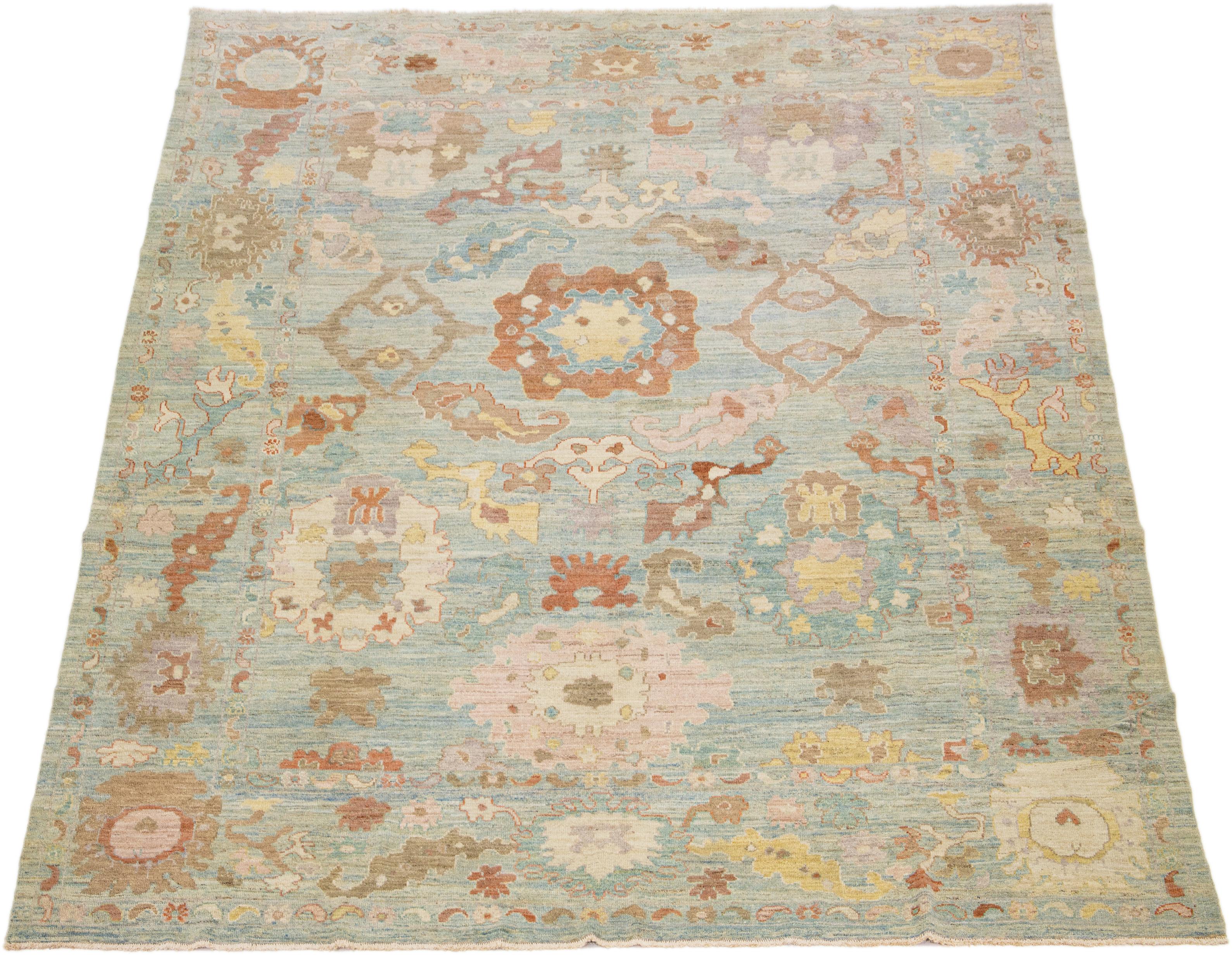 This modern reinterpretation of timeless Sultanabad design is beautifully manifested in an exquisitely hand-knotted wool rug, resplendent in its striking light blue shade. An intricate border delineates its all-over floral embroidery, embellished