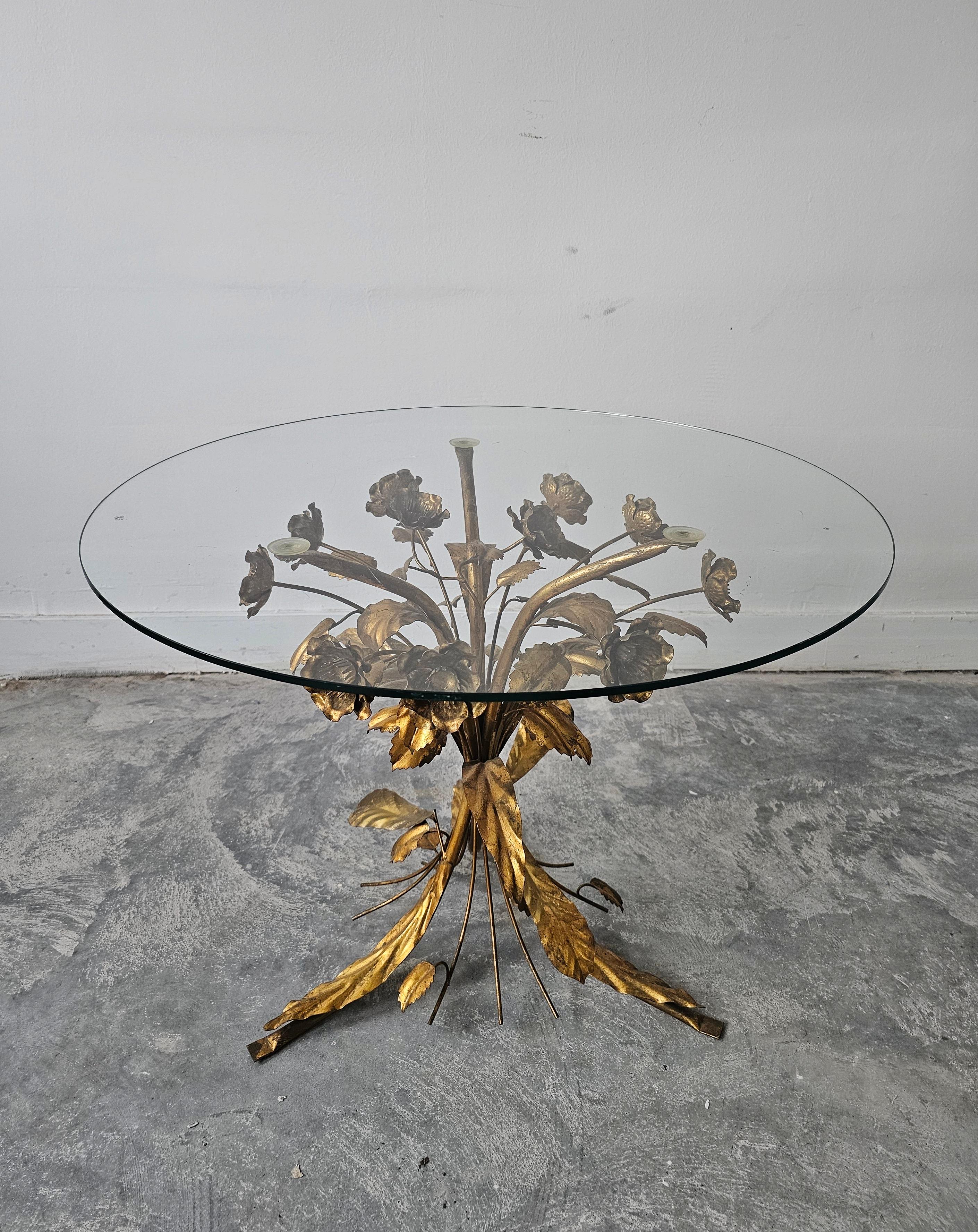 In this listing you will find an iconic Hollywood Regency Side Table designed by Hans Kögl in his characteristic manner, where assembled bouquet of gilt flowers is put together as a base of the table, with a simple round glass top. Made in Italy in