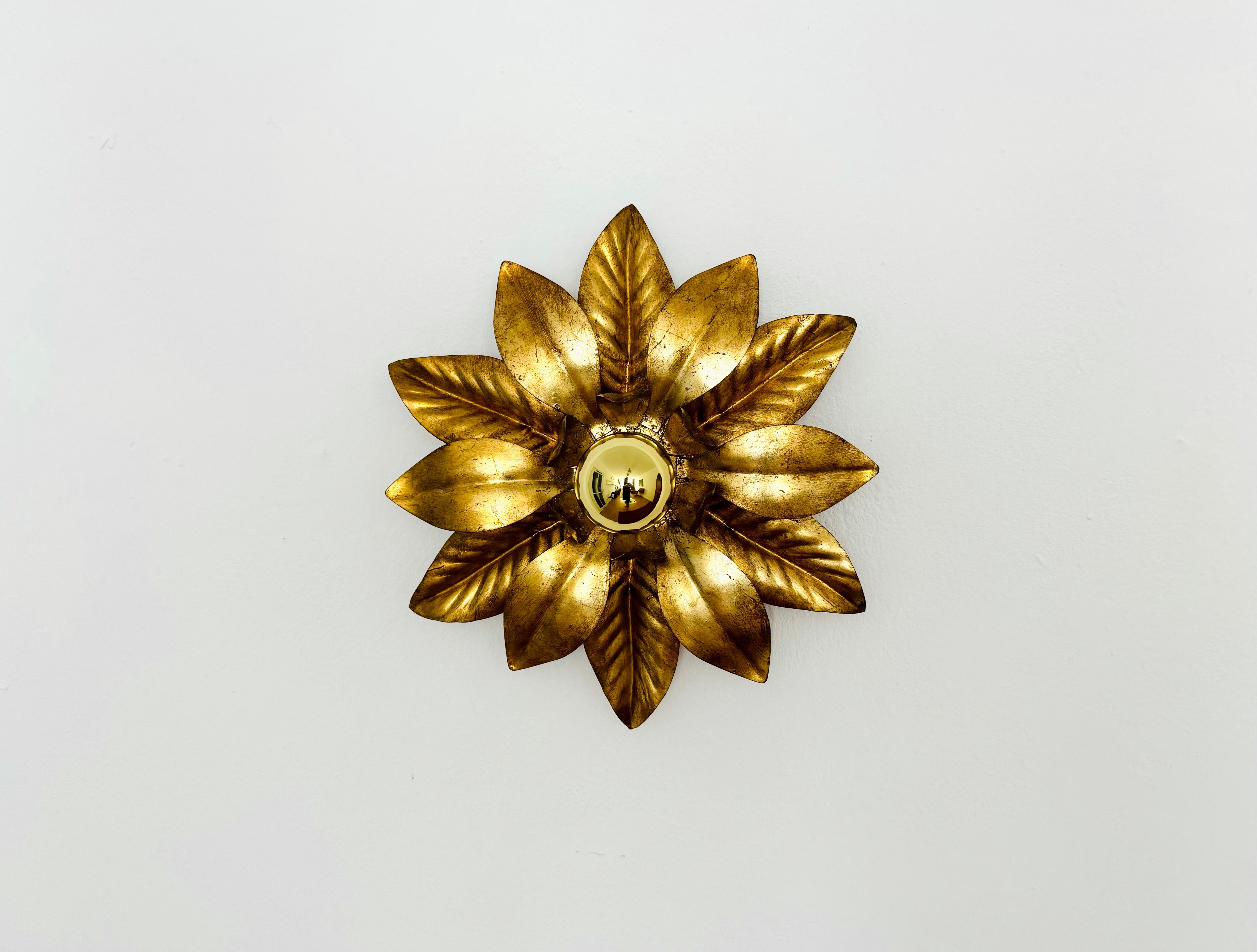 Sehr schöne goldene Hollywood Regency Wand- oder Deckenlampe aus den 1970er Jahren.
Die Anordnung der Blätter erzeugt ein spektakuläres Lichtspiel an der Wand.
Tolles Design und hochwertige Verarbeitung.

Bedingung: 

Sehr guter Vintage-Zustand mit