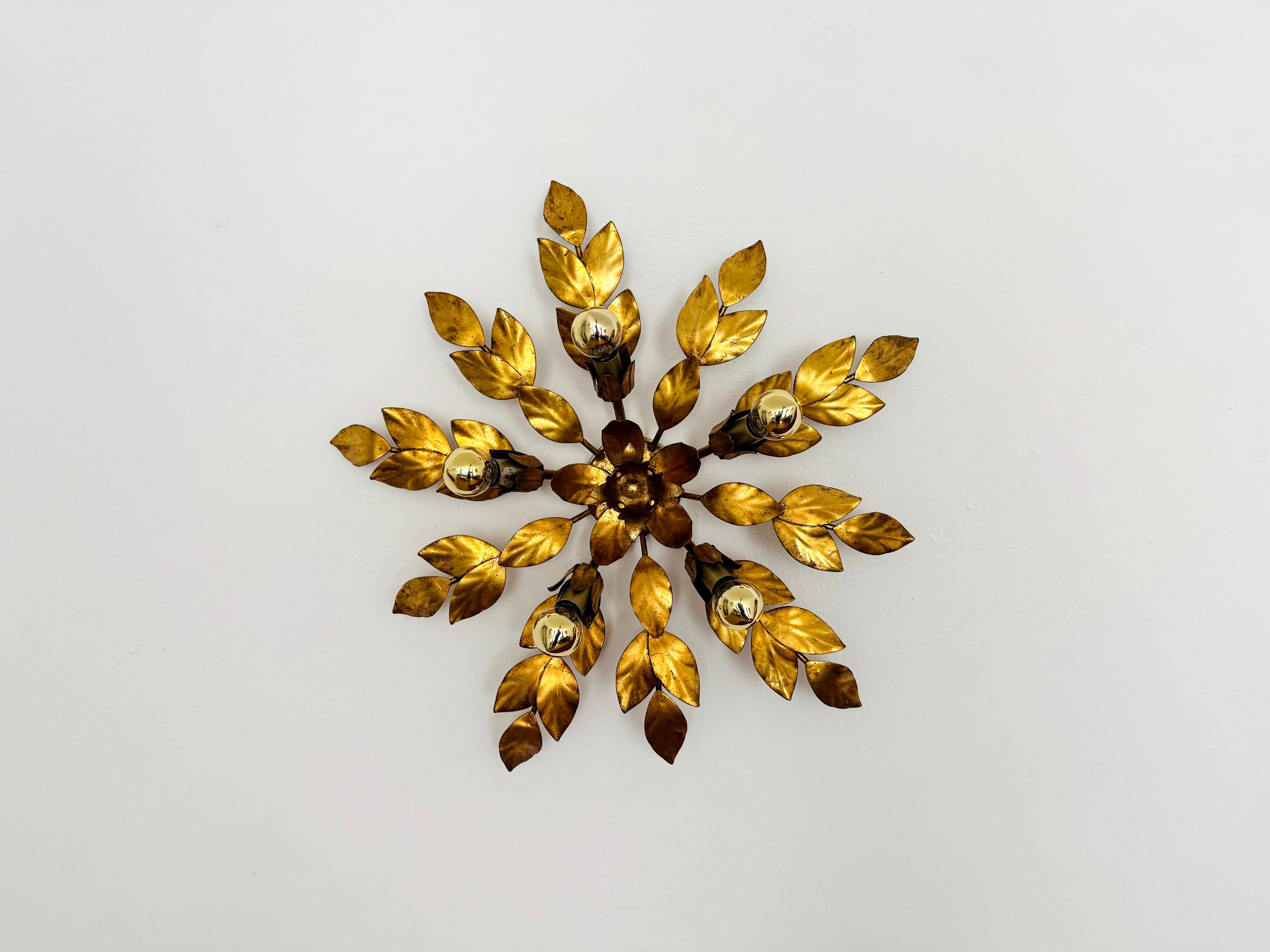 Very nice golden Hollywood Regency wall lamp or ceiling lamp from the 1970s.
The arrangement of the leaves creates a spectacular play of light on the wall.
Great design and high -quality workmanship.

Condition:

Very good vintage condition with