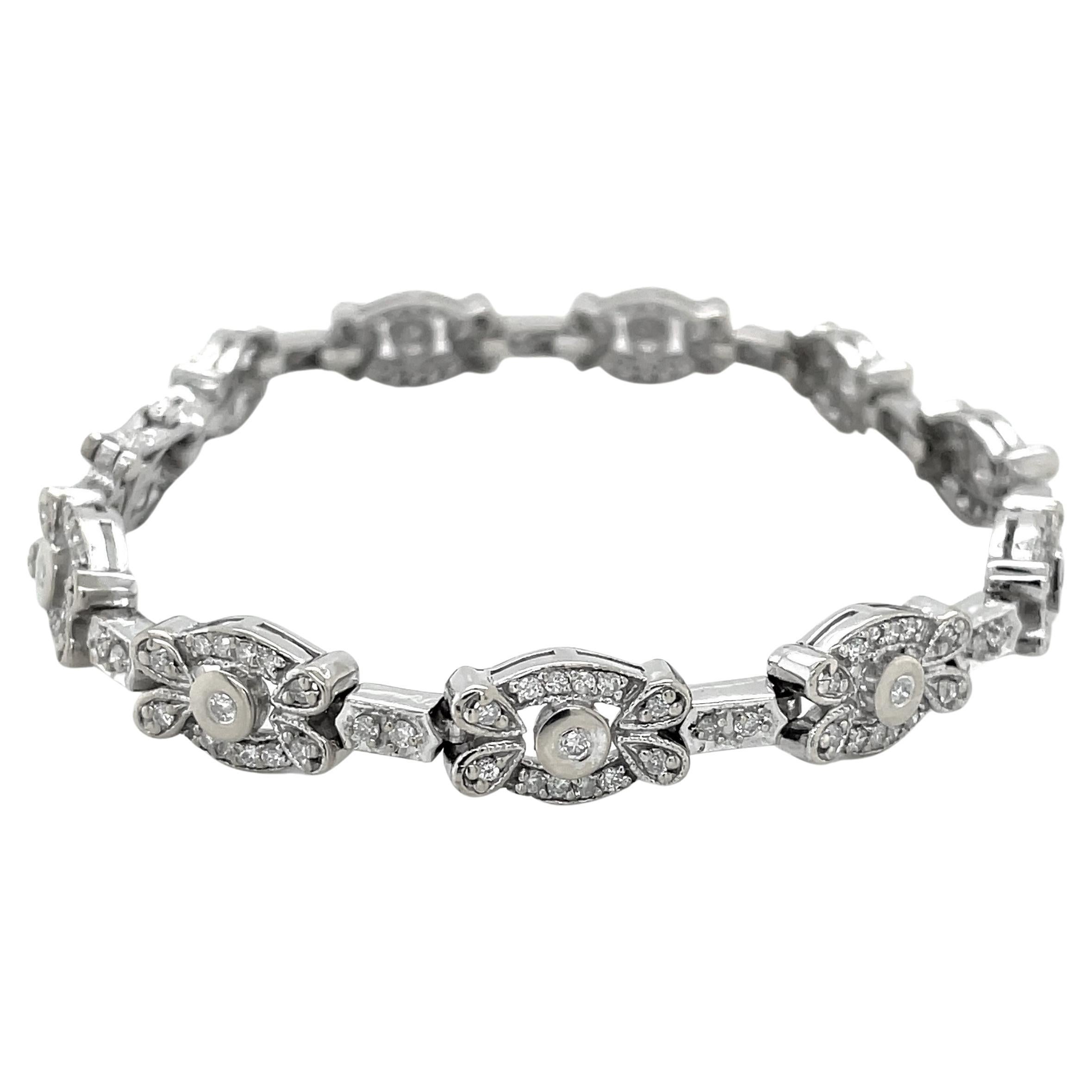 Universally engaging In 14 karat white gold, each link has a centered bezel set diamond surrounded by twelve accent diamonds creating a sparkling floral inspired design for this elegant tennis bracelet. Illuminated with 1.63 carats TW of H/SI round
