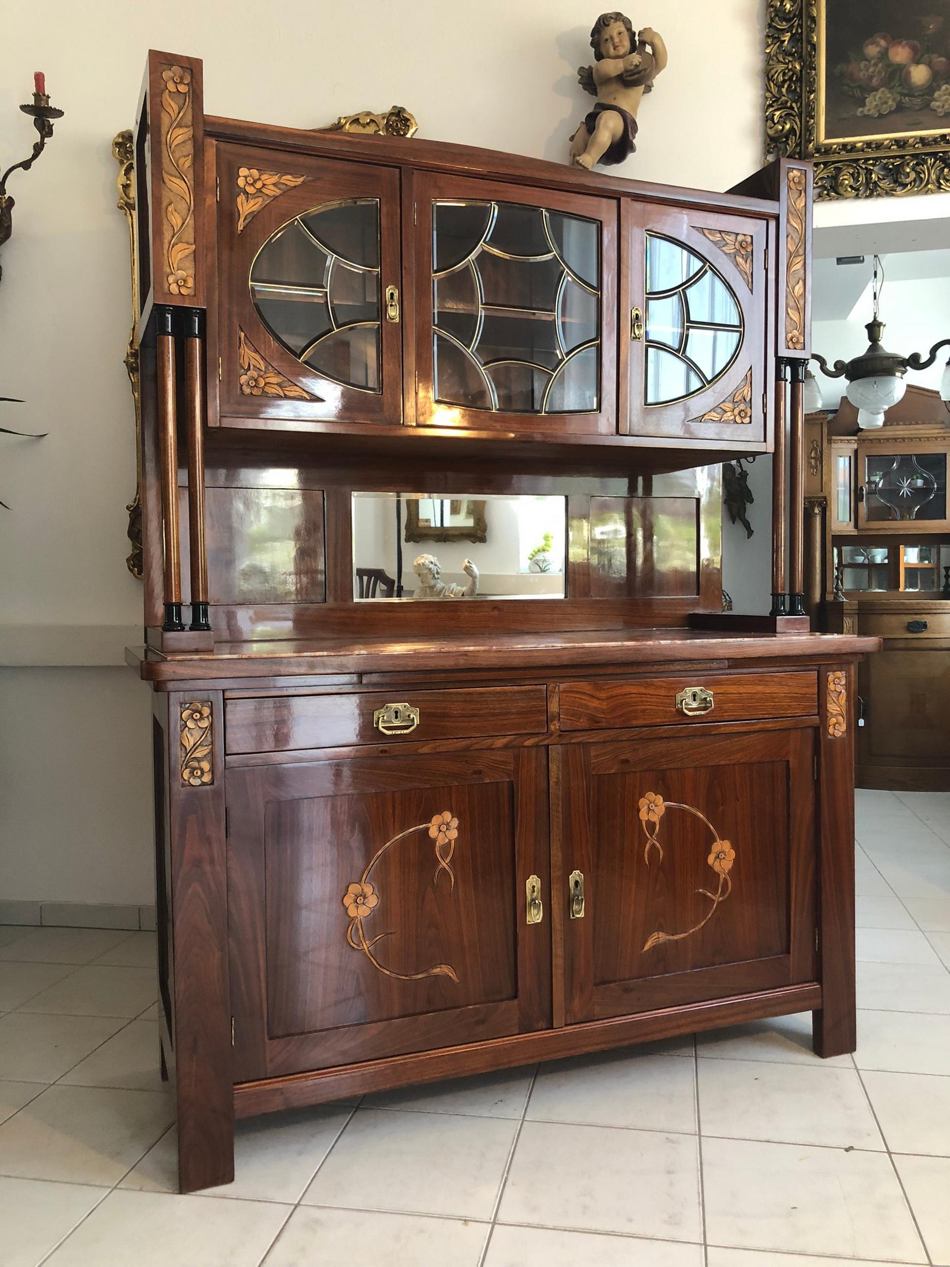 Unique and rare Jugendstil / Art Deco buffet cabinet with wonderful floral ornamentations and marquetry works. The design features double pillars on each side, fruitwood inlays on the doors and the outer frame, a central mirror, as well as a granite