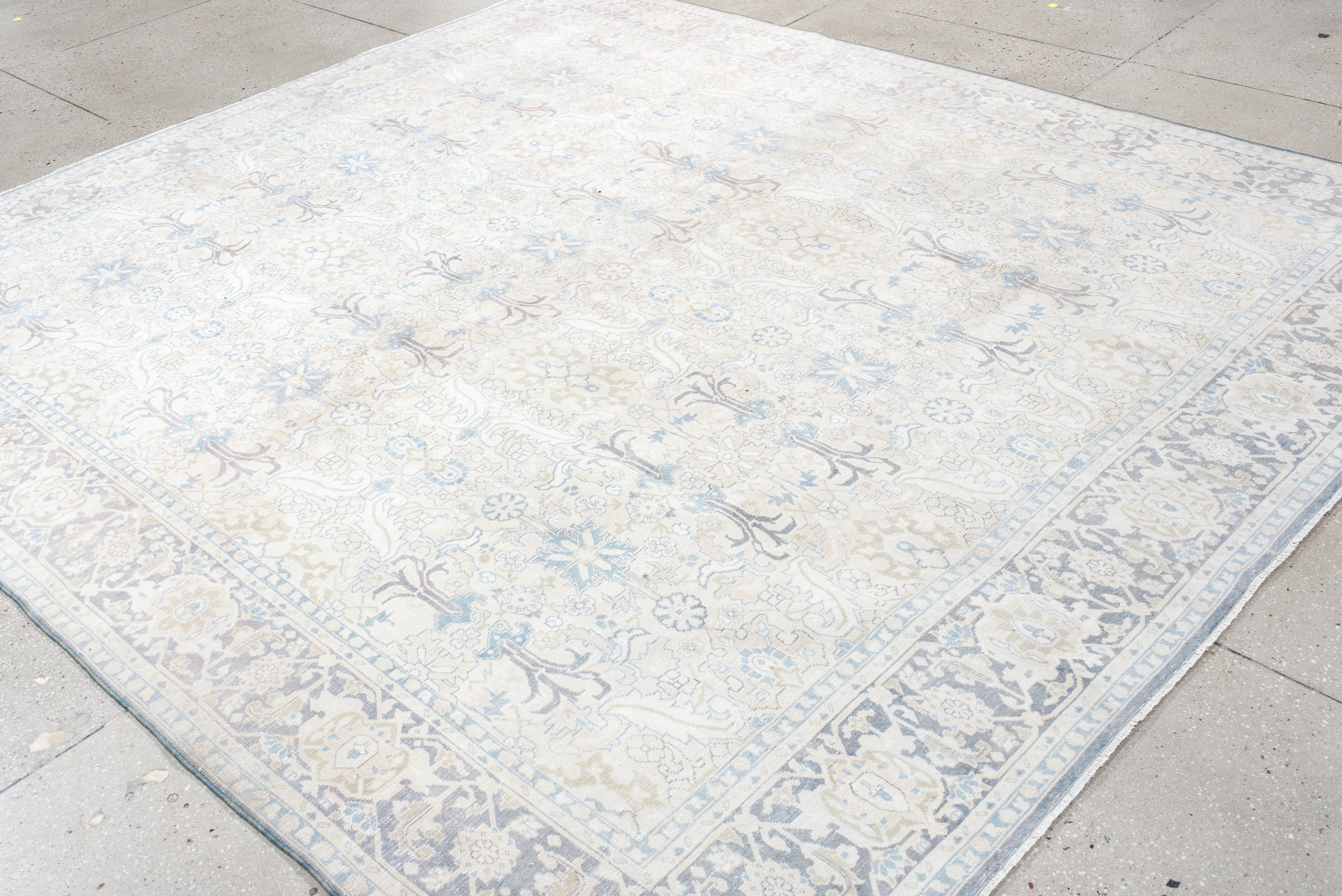 Dieser handgeknüpfte Tabriz-Teppich im Vintage-Stil besticht durch seine ätherische Farbpalette aus zartem Elfenbein, Puderblau und gedämpftem Lavendel, die ihm eine ruhige und elegante Ausstrahlung verleiht. Das fein gezeichnete florale Gitter