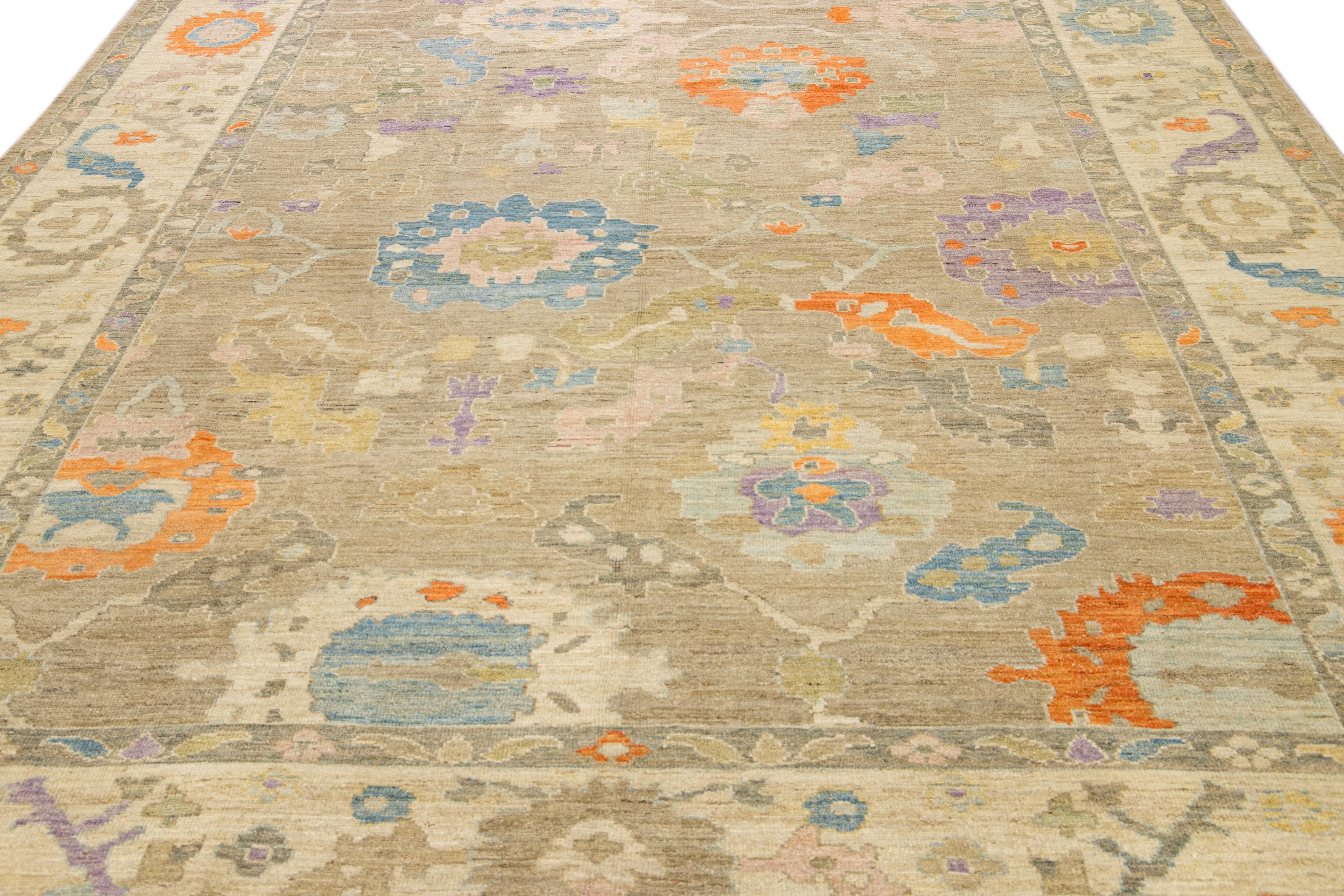 Ce superbe tapis Sultanabad noué à la main présente un design moderne sur une base marron clair. Le tapis persan est bordé d'un cadre beige et agrémenté de nombreuses couleurs qui forment un motif floral attrayant.

Ce tapis mesure 10'4