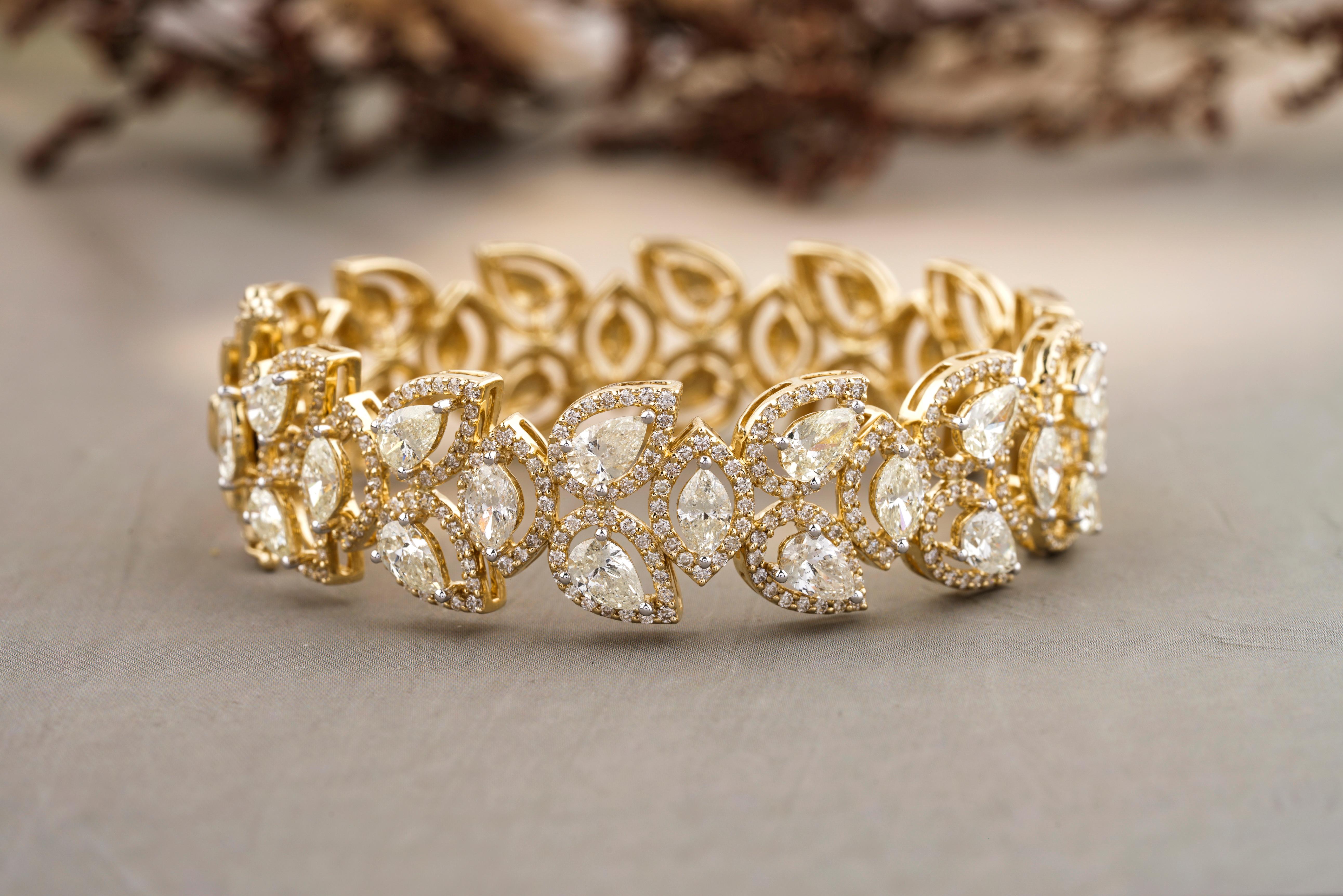 The Marquise & Pear Diamond Bracelet is a stunning piece of jewelry crafted from 18k solid gold. The bracelet features a unique design, incorporating marquise and pear-shaped diamonds in a floral pattern. The diamonds are carefully set within the