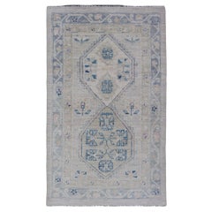 Oushak-Teppich mit Blumenmedaillon und Stammesmotiven und cremefarbenem Hintergrund mit Medaillon