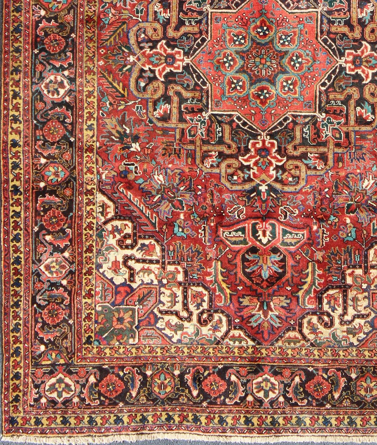 Floral medallion vintage Persian Heriz rug in red, blue, and golden yellow, rug h-501-34, country of origin / type: Iran / Heriz, circa 1950.

This magnificent vintage Persian Heriz carpet from the mid-20th century (circa 1950) bears an exquisite