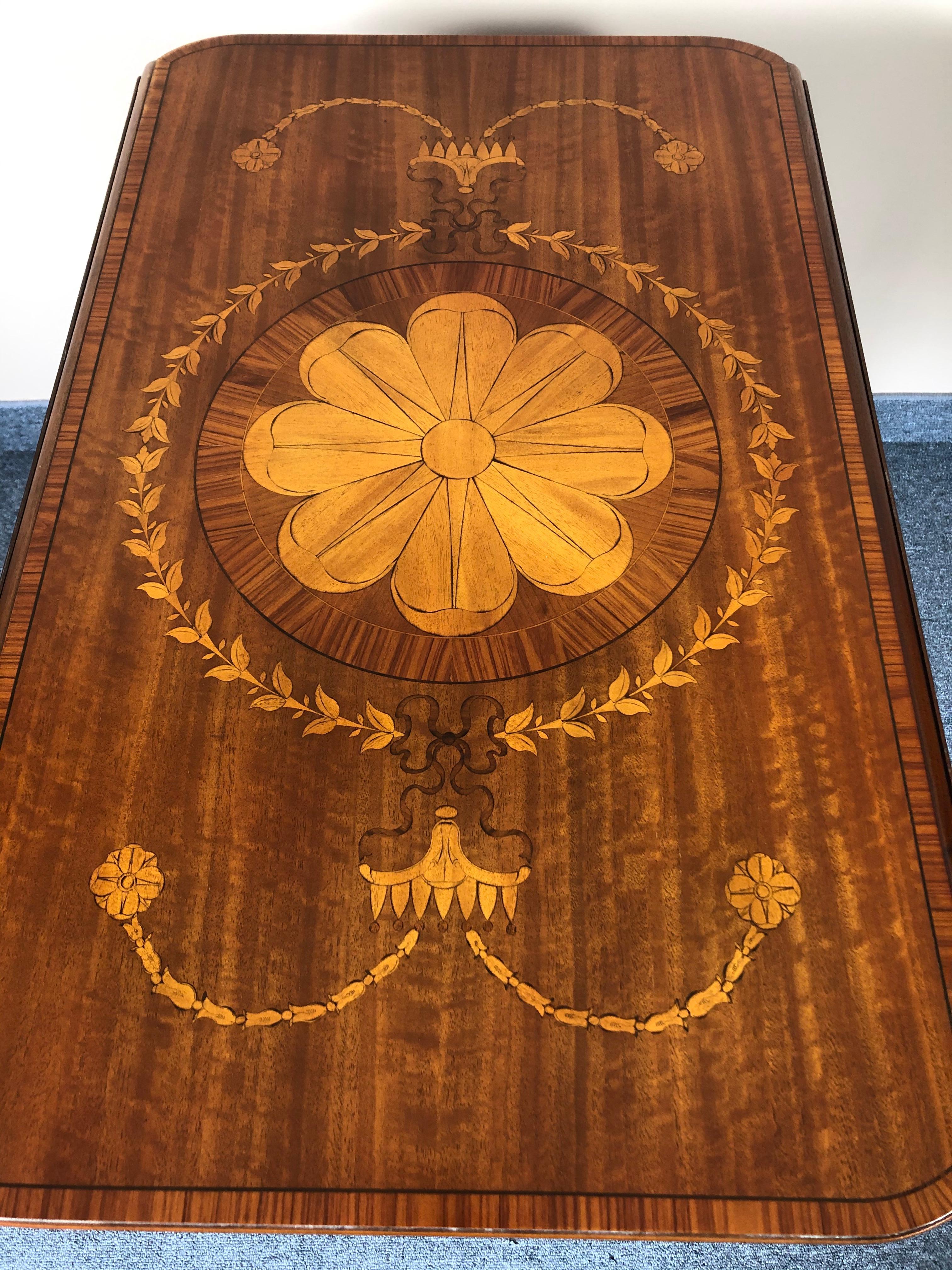 Ein schöner Dropleaf- oder Pembroke-Tisch mit gemischten Holzintarsien, darunter ein zentrales Blumenmandala, eine einzelne Schublade und hübsche verjüngte Beine, die ebenfalls mit Intarsien verziert sind.
Wenn geöffnet 37,25 W