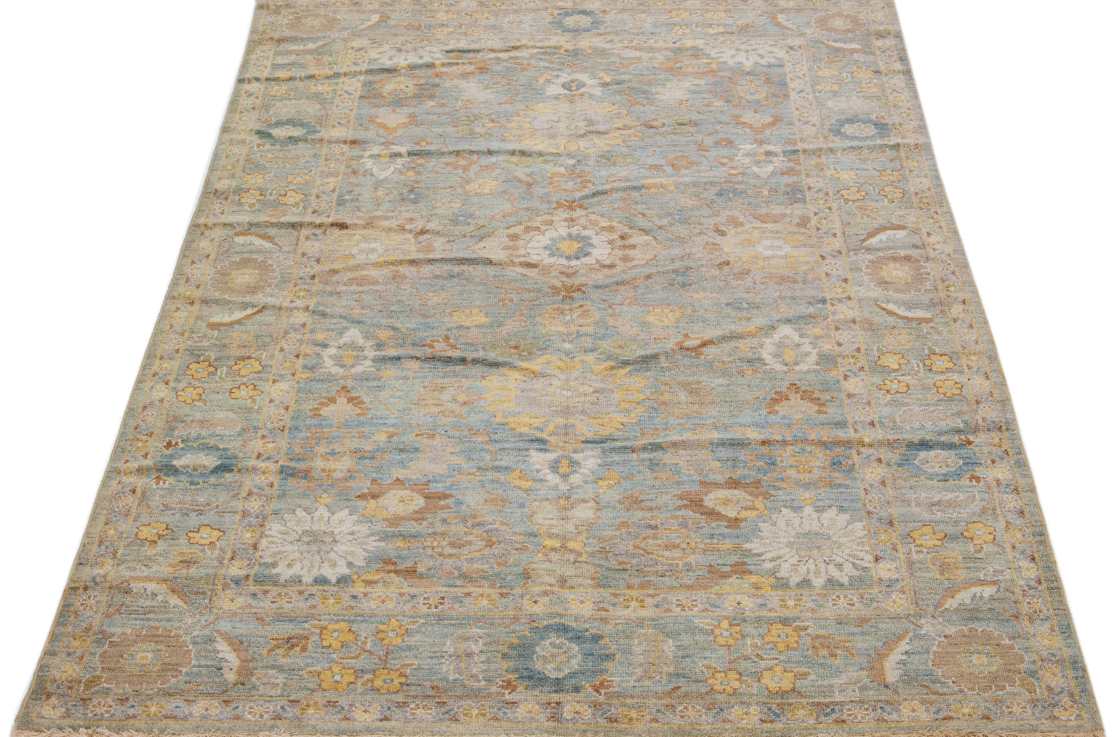Beautiful modern Sultanabad hand-knotted wool rug with a blue color field. This rug has a designed frame with brown, green, and yellow accents in a gorgeous all-over floral motif.

This rug measures: 6' 2