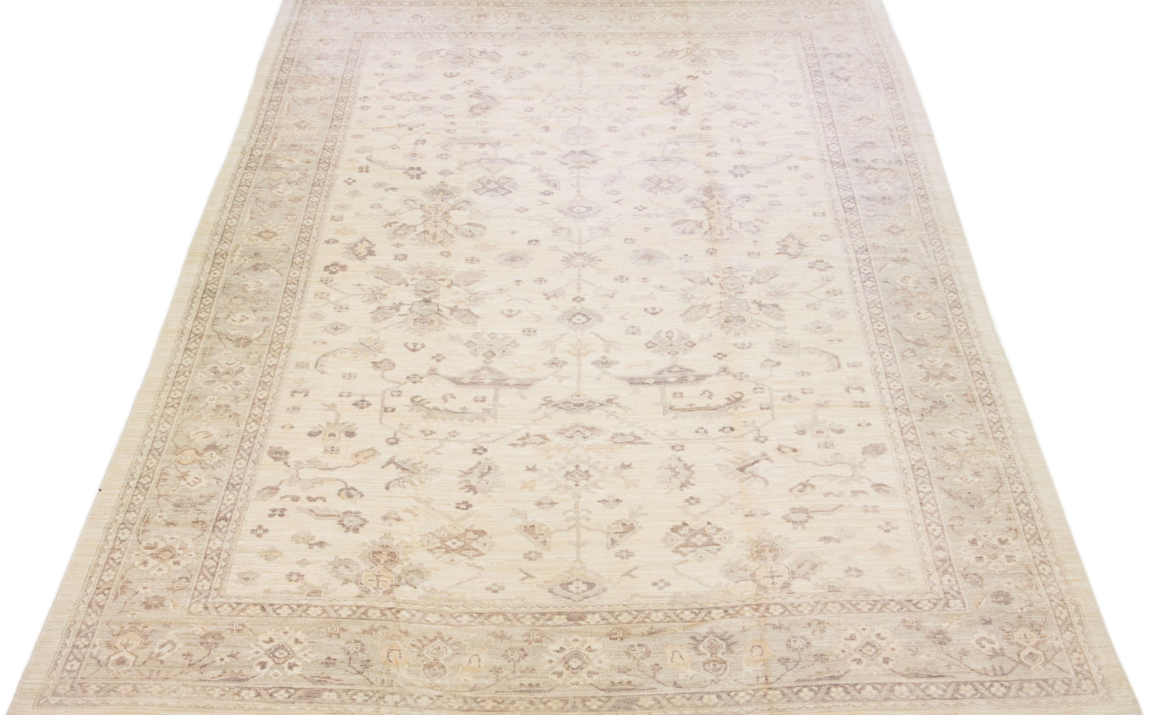 Beautiful modern Oushak hand-knotted wool rug with a beige color field. This Turkish Piece has gray accent colors in a gorgeous all-over floral design.

This rug measures: 11'7