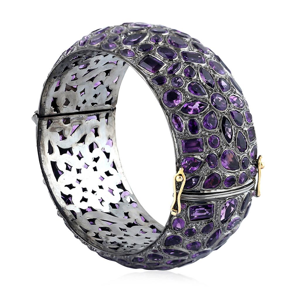 This floral mosaic style amethyst bangle is set in silver and is op-enable on side with box clasp with 2 safety locks. 

18KT: 4.310g
Silver: 57.228g
AMETHYST: 52.71ct
