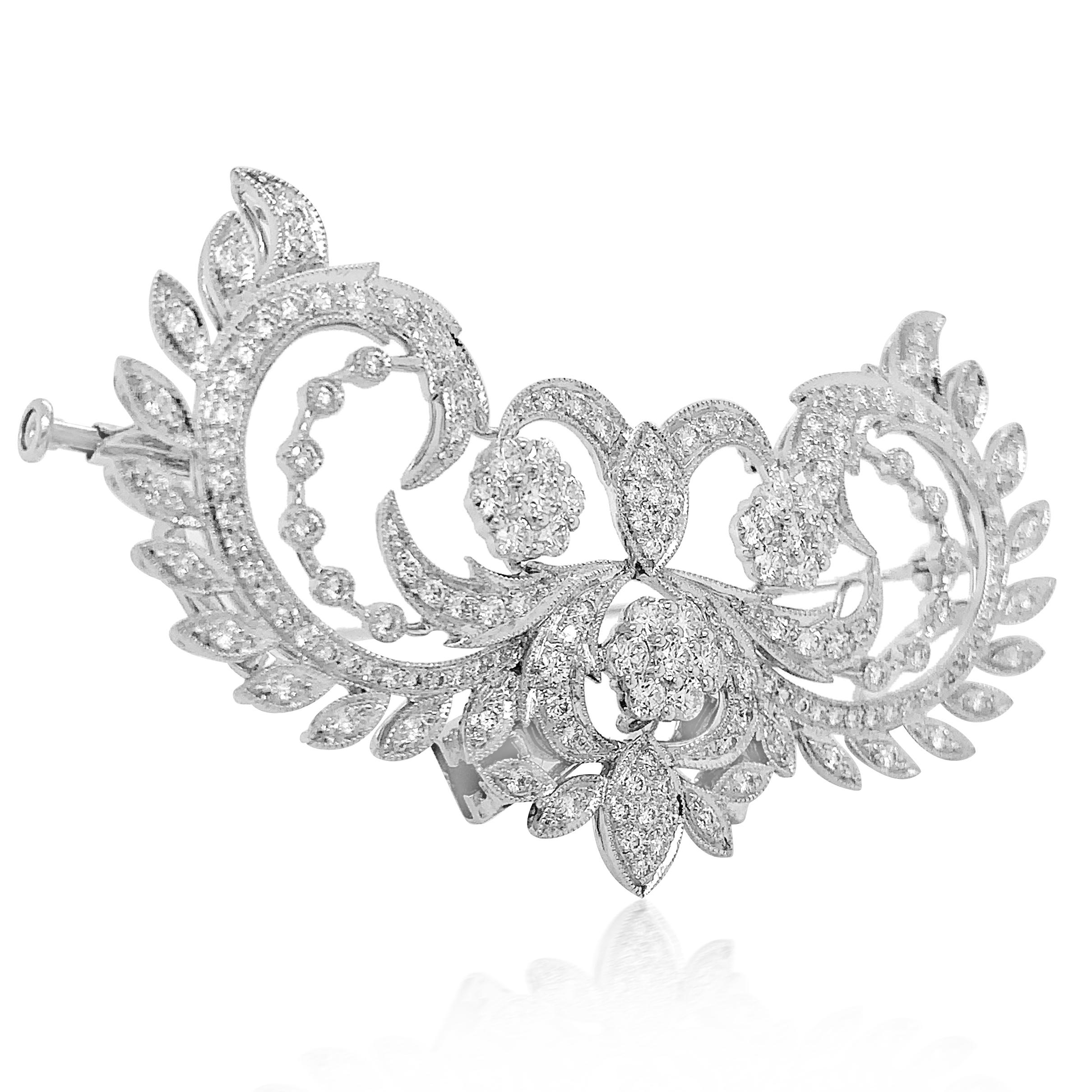 This breathtaking floral motif diamond brooch/pendant is crafted in solid 18K white gold, weighing  18.48 grams and measuring 65x40mm. It is centered with three 5-petal flowers composed of six 0.04-carat round-cut diamonds. Further enhanced with