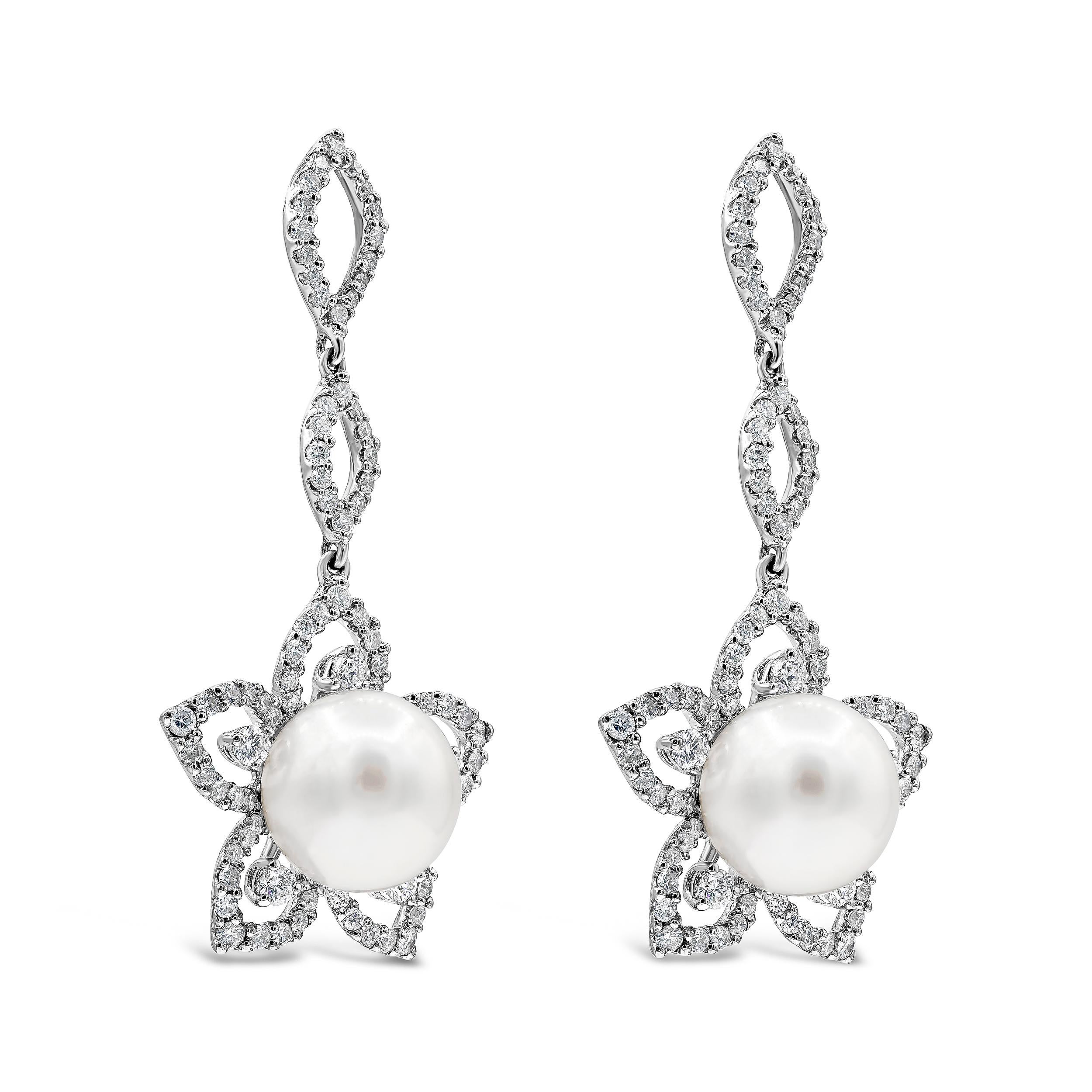 A unique pair of earrings of open-work design showcasing a white pearl set in a floral motif setting encrusted with round brilliant diamonds. Suspended on a line of round diamonds arranged in a marquise shape design. Diamonds weigh 1.88 carats