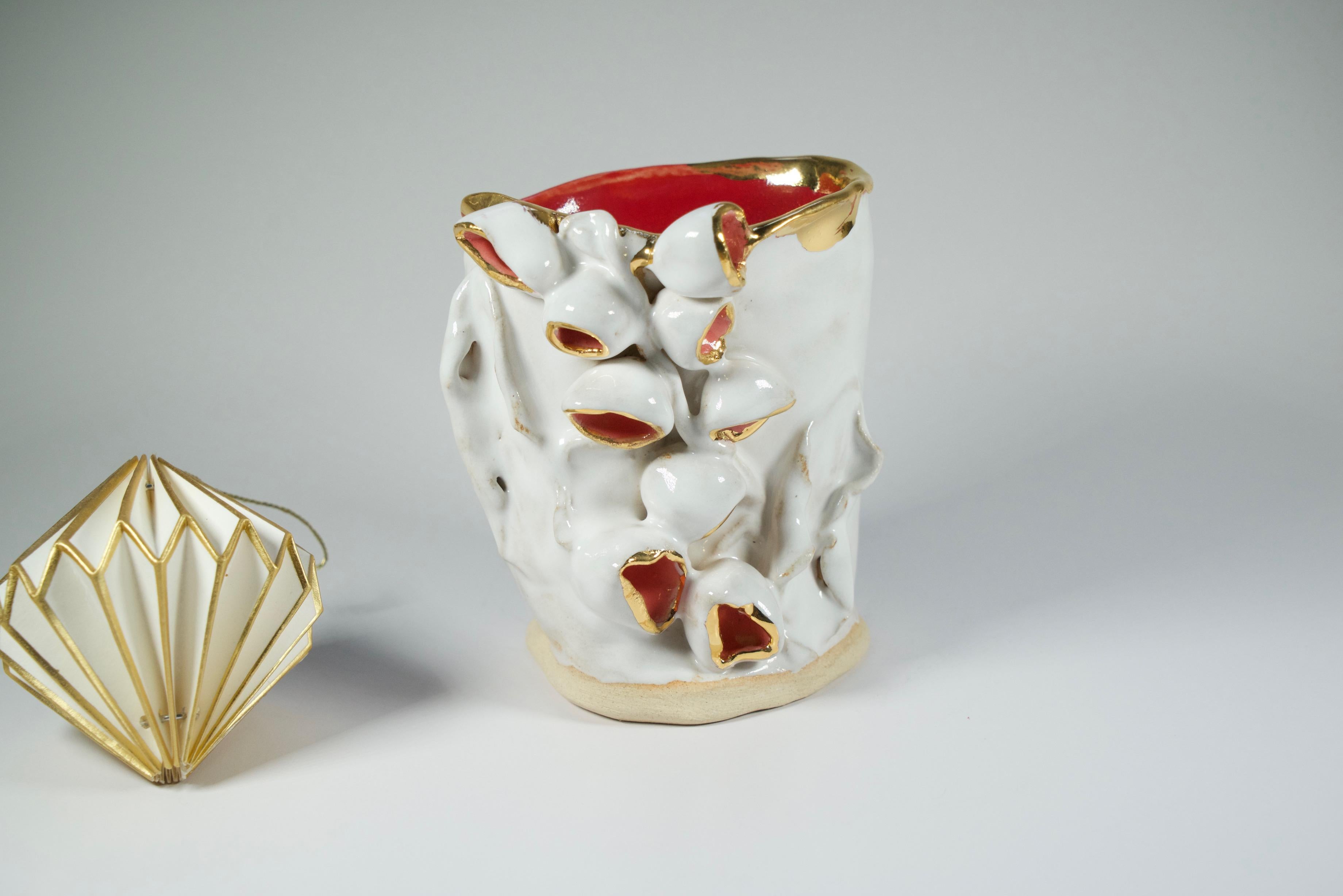Artistics Creations in stoneware, hand built and hand glaze (Créations artistiques en grès, fabriquées et émaillées à la main) 
orné d'un lustre d'or.
L'artiste interprète l'art floral à sa manière, vase surréaliste et ludique de la collection