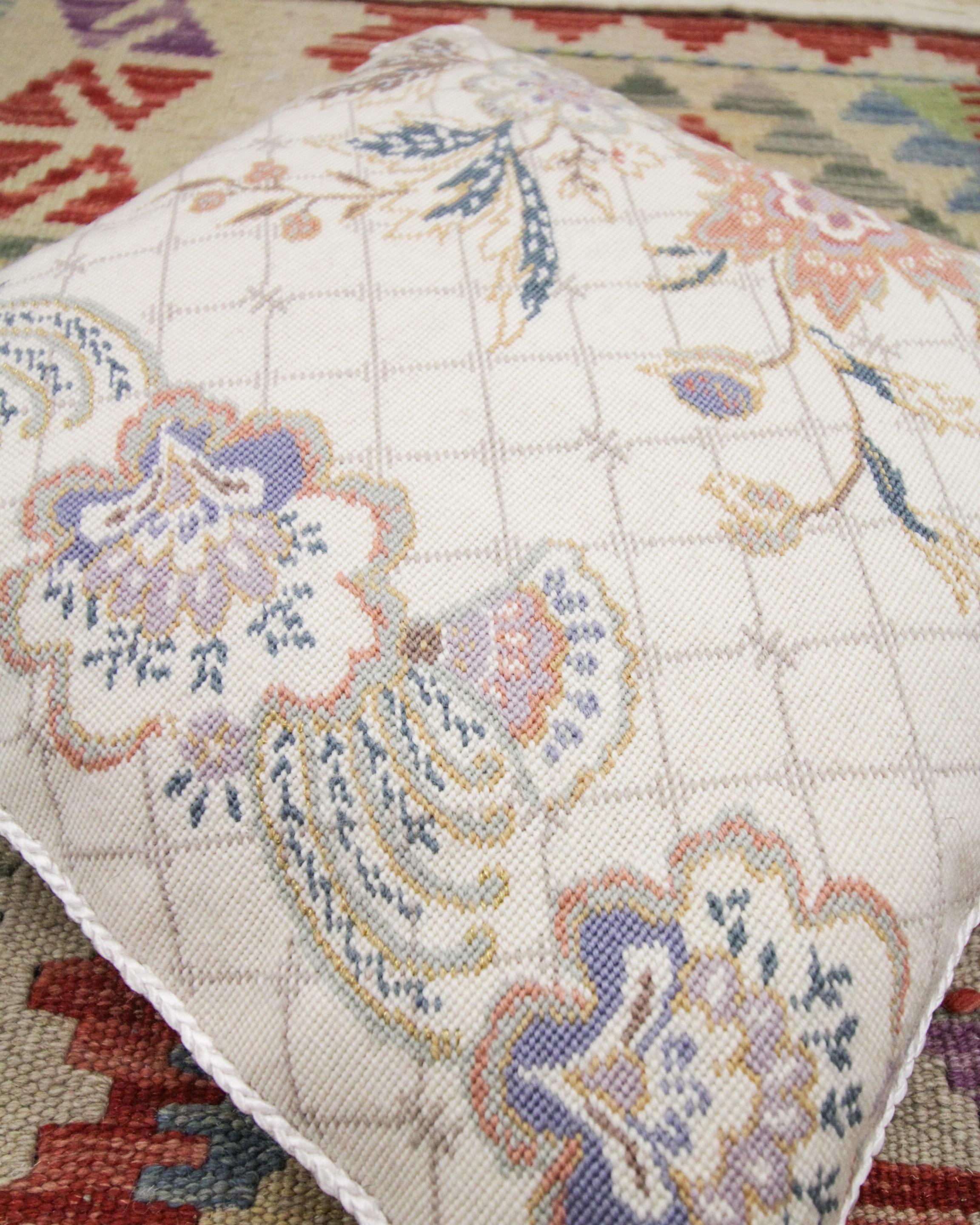 Questa fodera per cuscino a punta d'ago, unica nel suo genere, è stata tessuta a mano con un disegno floreale paisley, con accenti di viola, blu, arancione e grigio su un sottile sfondo color crema. Il colore e il design di questa fodera per cuscino