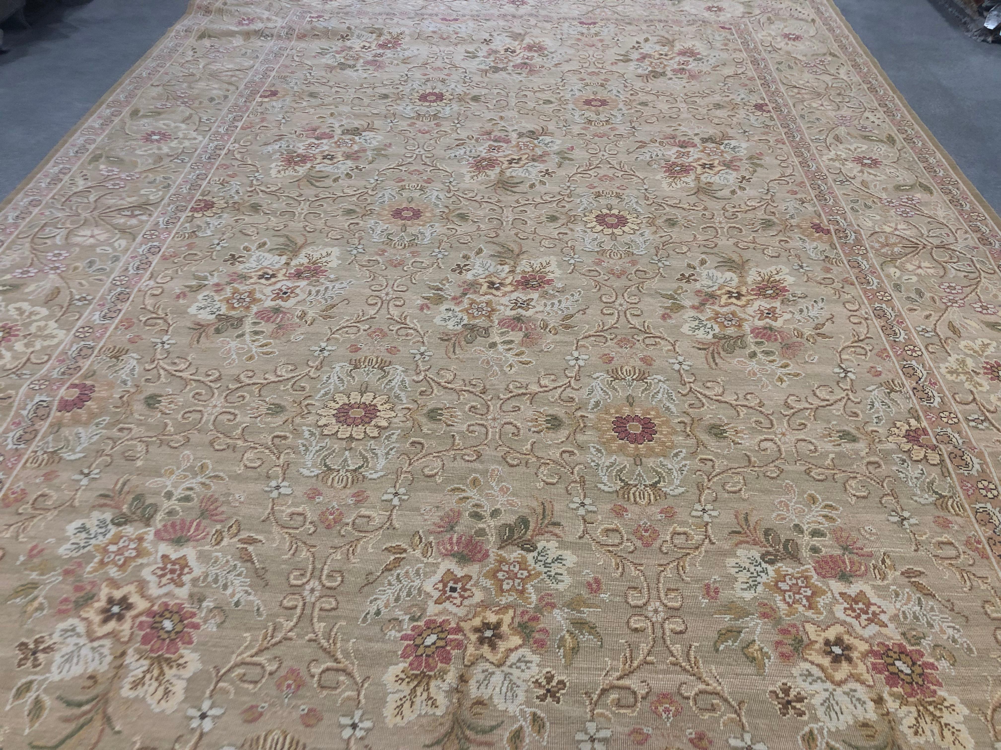 A charming wool area rug featuring pink, yellow and cream bouquets against a neutral beige background. Traditional elegance at its finest. Hand knotted. Made in Europe.