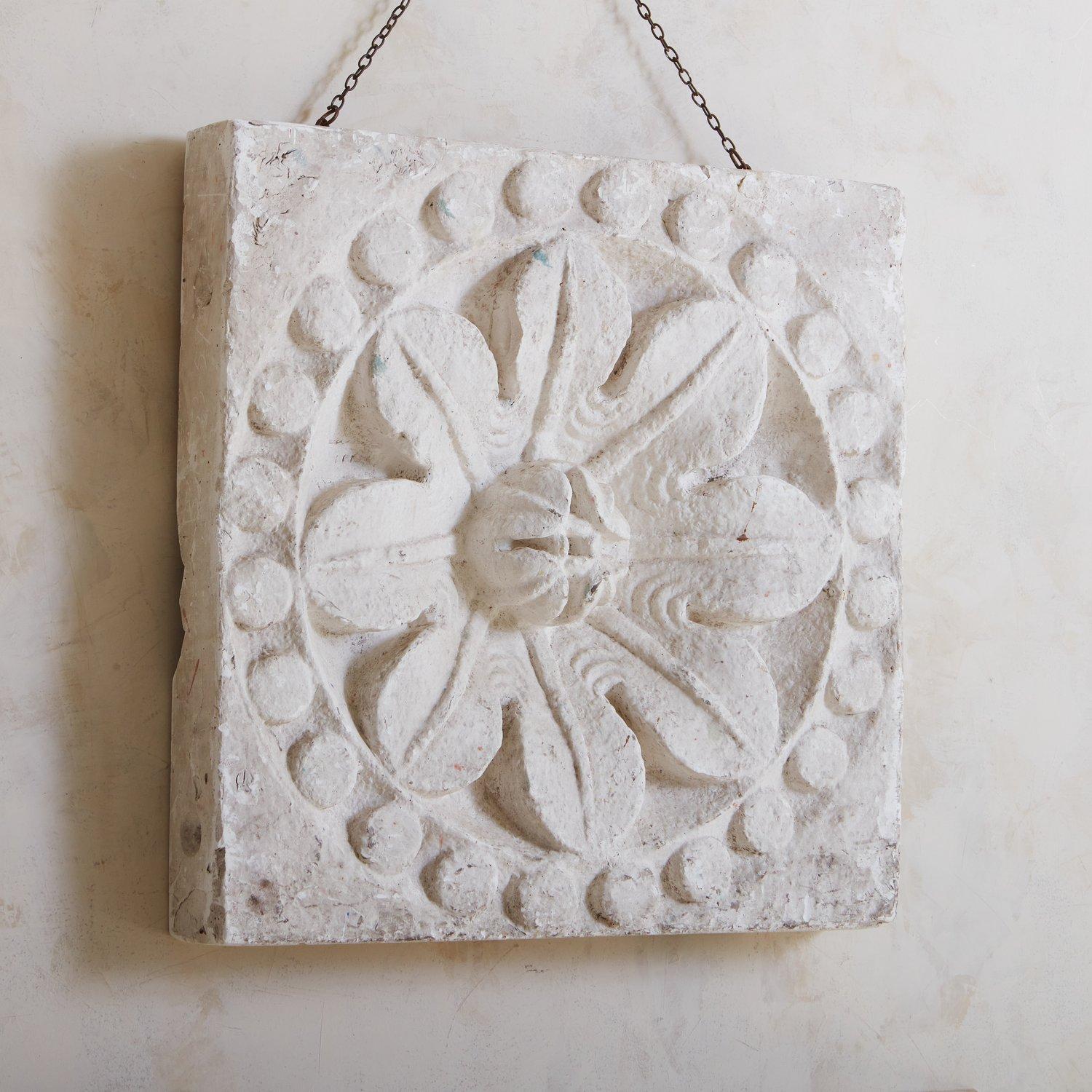A vintage plaster wall relief featuring a floral motif with circular details. This piece has a beautiful patina and time honored wear. Hanging hardware included. Sourced in France, 20th Century.