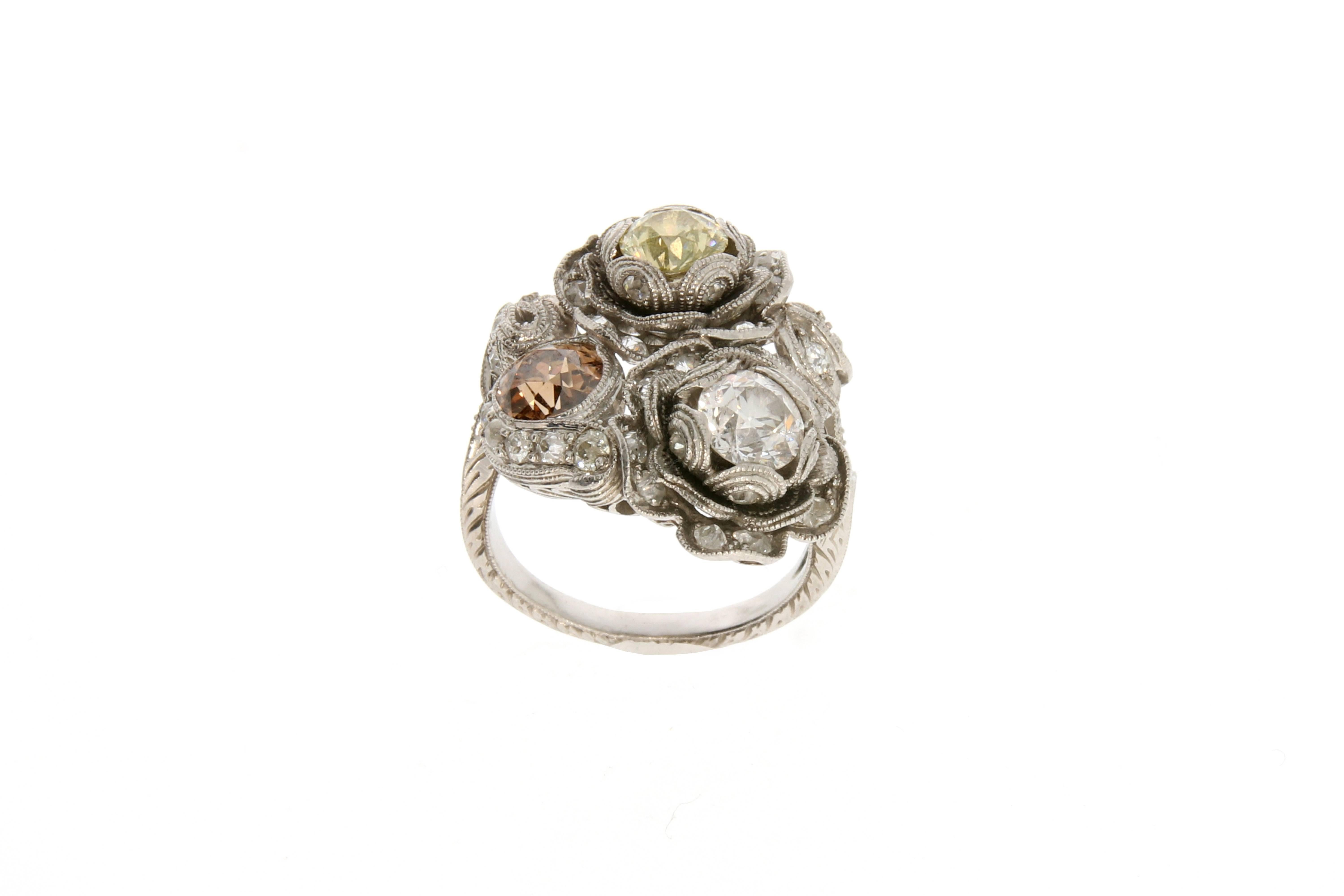Exceptional filigree and floral platinum cocktail ring. The flowers are centred with two fancy coloured diamonds and one white diamond (fancy brown (circa 0.6 carats), fancy yellow (circa 0.5 carats)  and white (circa 0.6 carats).
34 brilliant