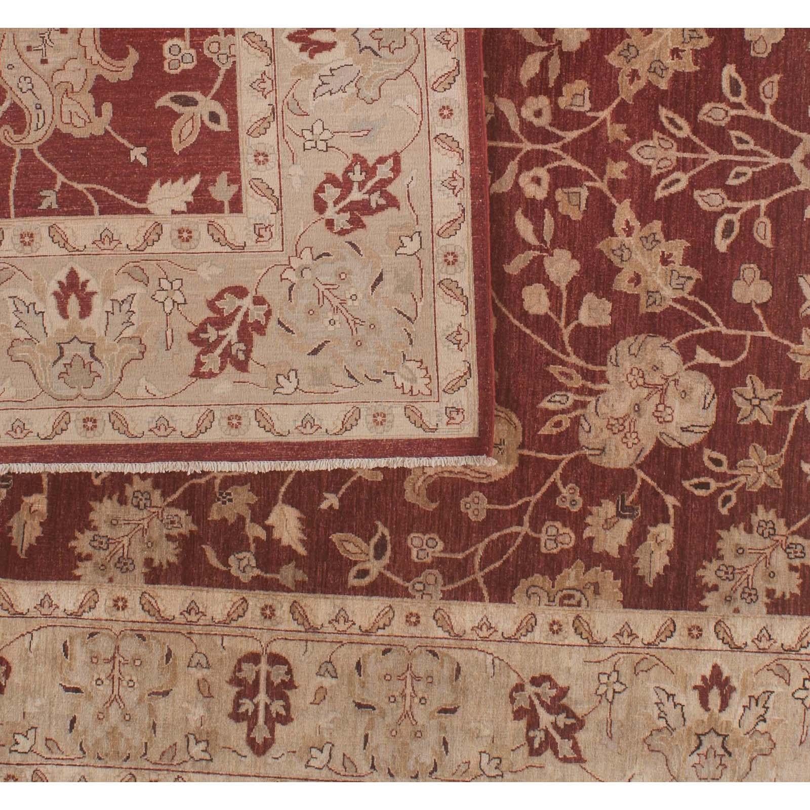 Leaves are the dominant theme in this traditional Pakistani floral motif area rug. Red leaves dance in a wide beige border while an intricate pattern of leaves and blossoms stands out against a bold red core. This hand knotted wool rug uses vegetal