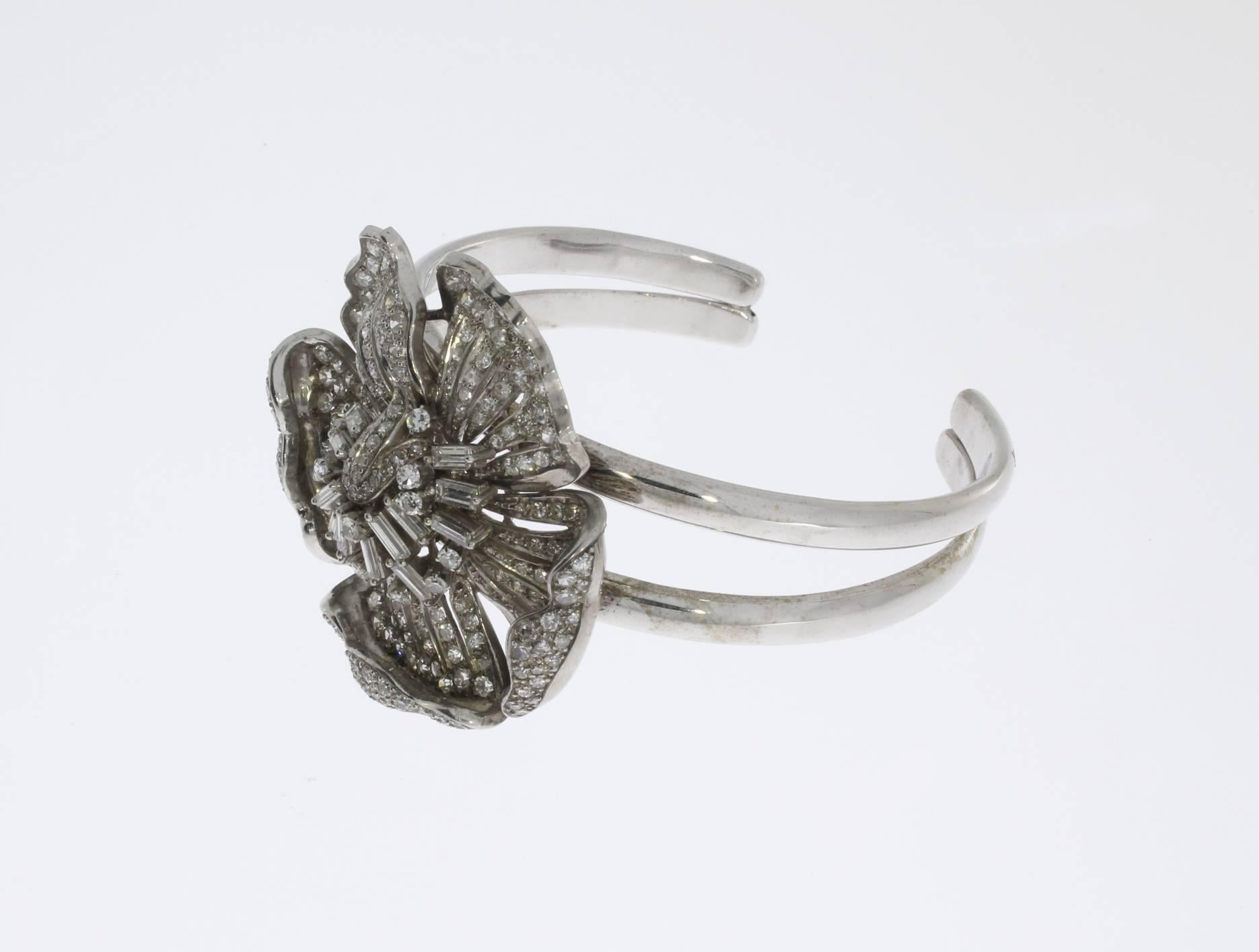 Designed as a flower entirely pavé-set. Platinum and 18 carat white gold bangle bracelet with 223 chaton-cut diamonds and 14 baguette-cut diamonds with a total weight of aproximately 9,5 ct. Weight: 62,21 g. Diameter: 2.24 in ( 5,7 cm ), Diameter