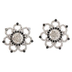 Borchie con diamanti bianchi e neri a forma di fiore realizzate in oro bianco 18 carati