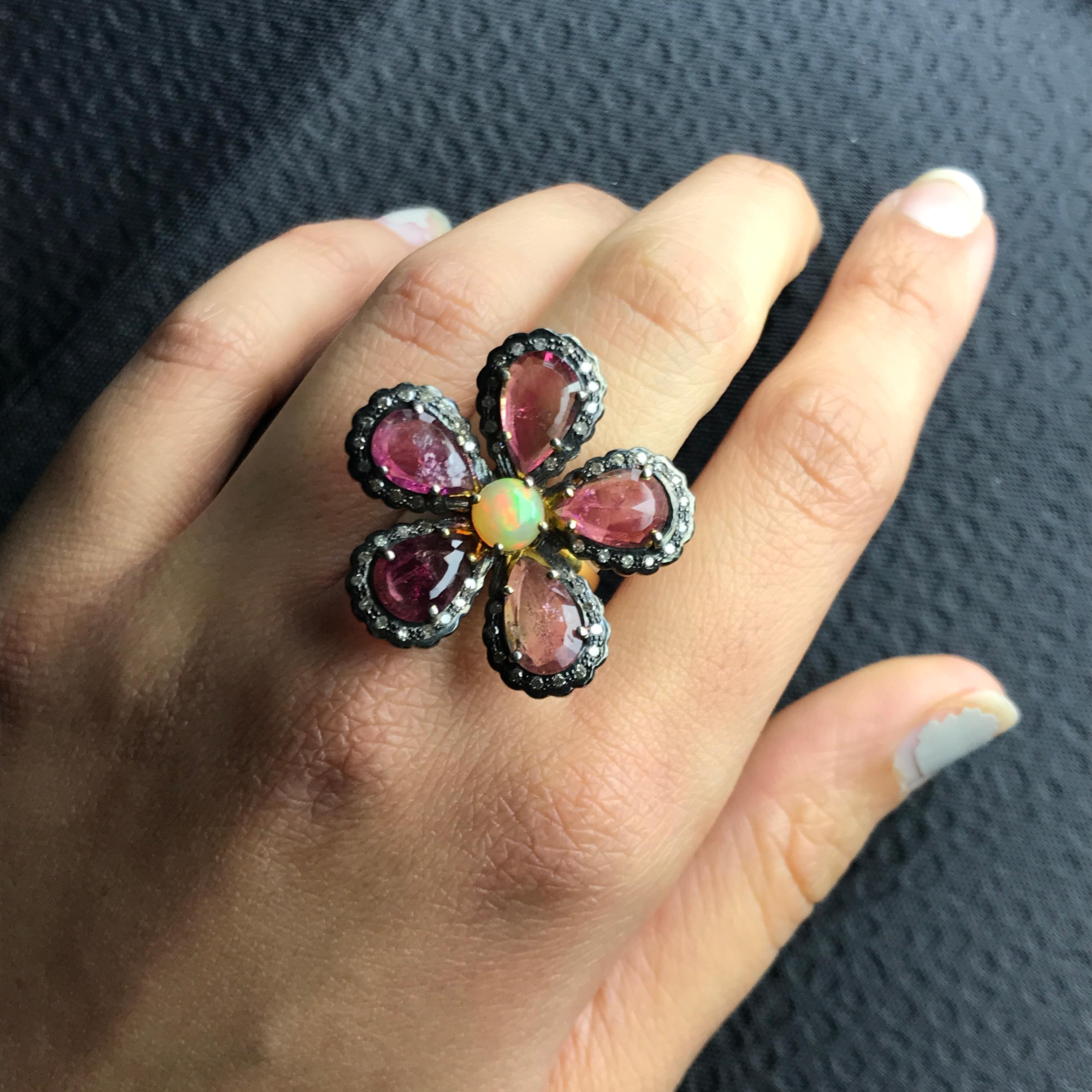 A stunning, statement floral design ring with Tourmaline, Opal and Diamond set in silver. The black rhodium polish gives the ring a beautiful, antique look. Currently a size 6.5, can be resized. 