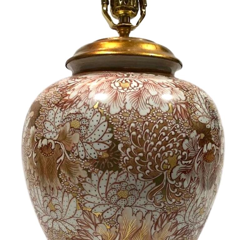 A single circa 1940's Japanese porcelain lamp with floral decoration in coral tones and gold details on gilt wood base.

Measurements:
Height of body: 16