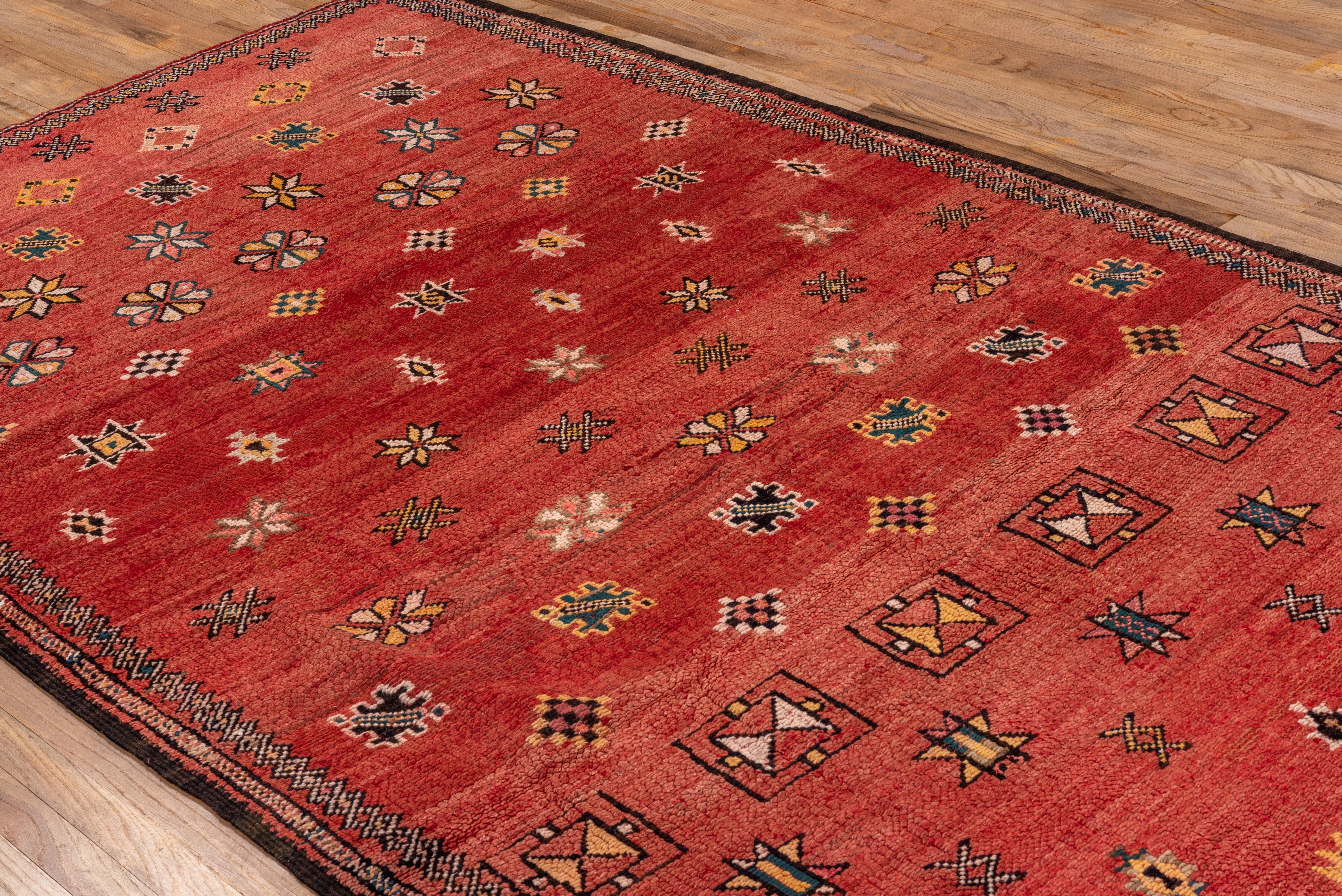 The soft red pallet of this rug is warm and inviting for any space, with delicately woven floral, star shaped accents across the field of the carpet - this is a beautiful vintage design from the mid twentieth century. 