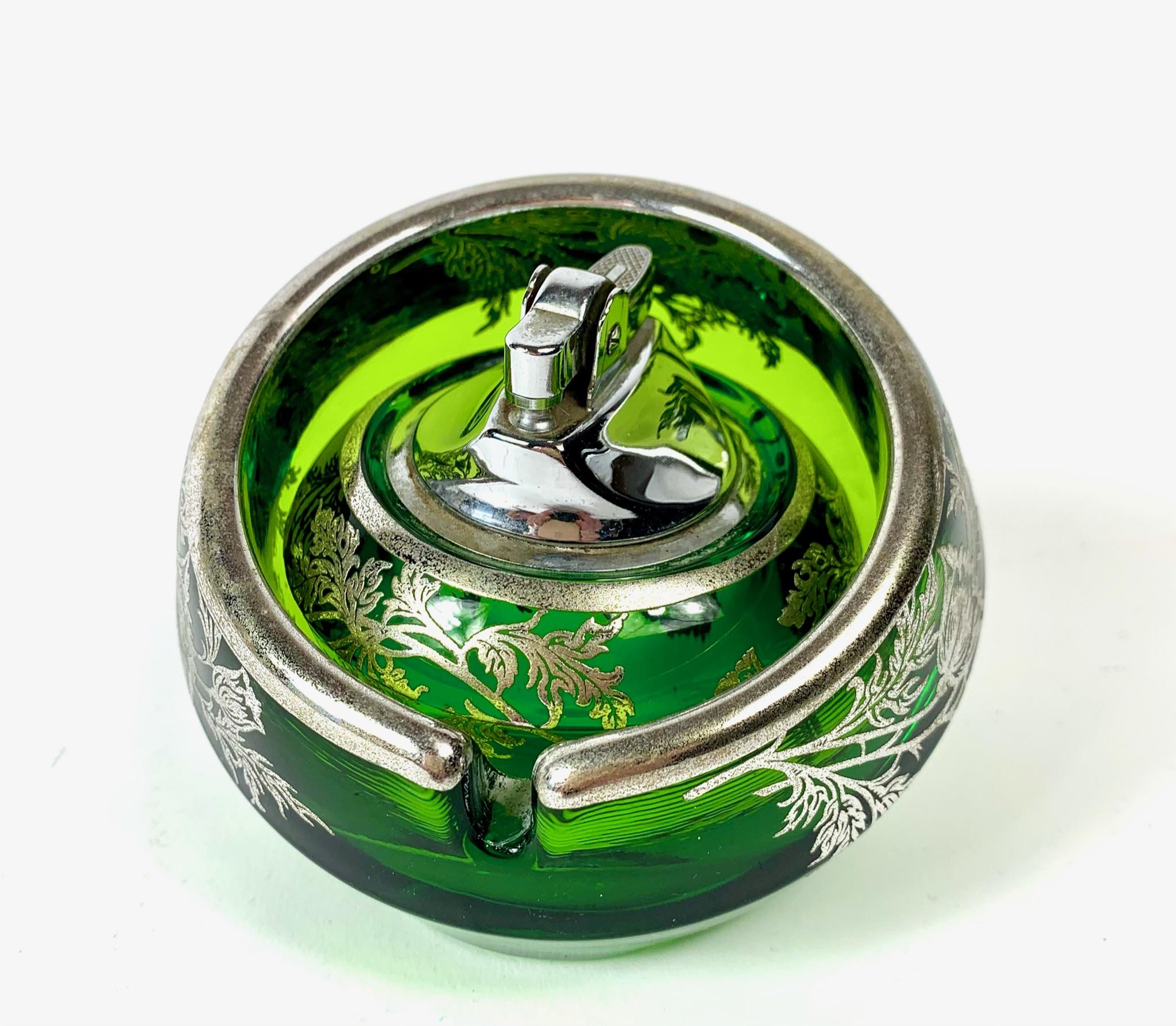 Stunning Mid-Century Modern art glass orb shaped ashtray with matching lighter made by Viking Art Glass from the 1950s 1960s. The thick green glass is decorated with a sterling silver floral pattern called 