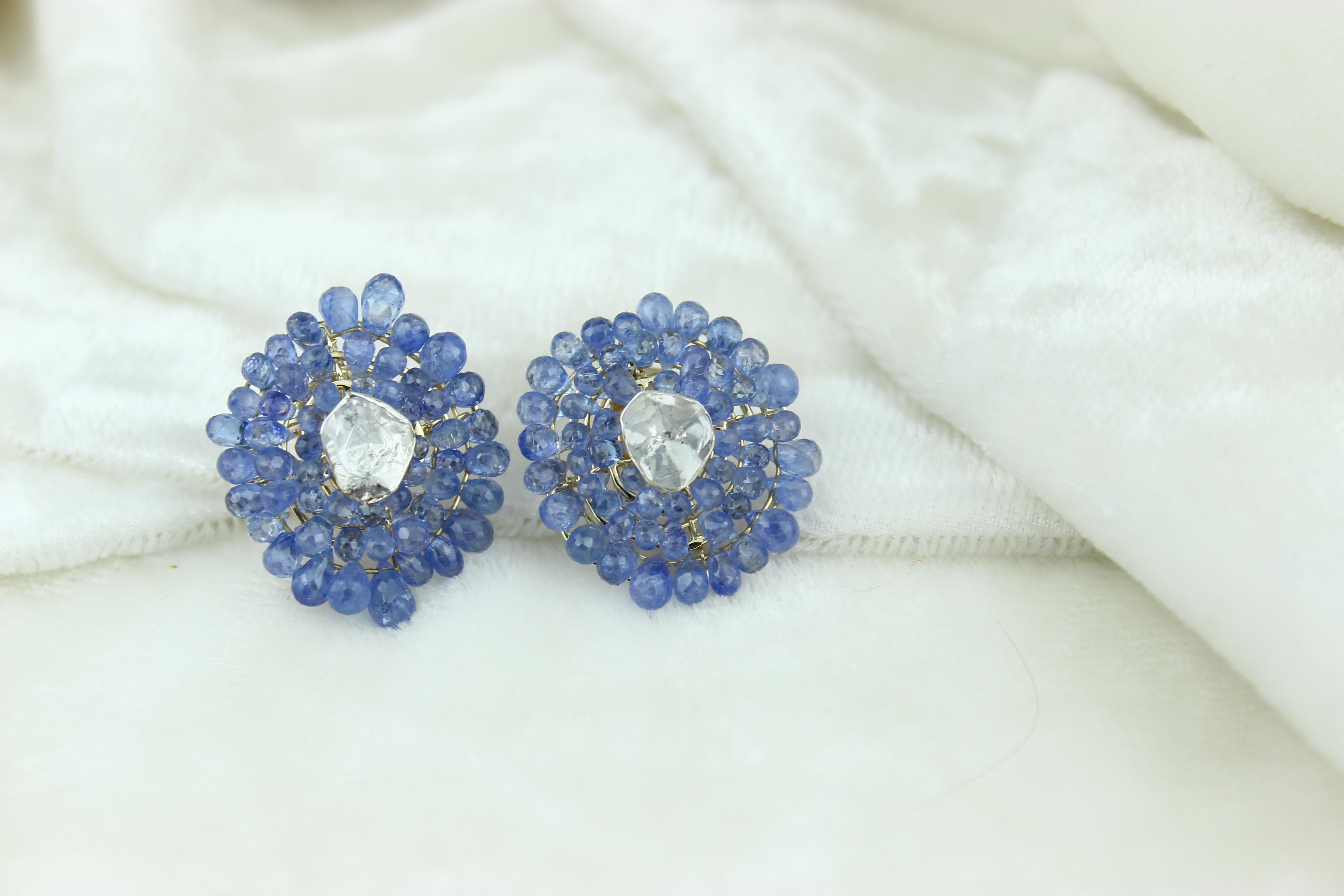 Captivating floral stud earrings showcasing a stunning combination of a polki at the center surrounded by blue briollete gemstones. Crafted with precision in 18k solid gold, these earrings radiate opulence and charm. The floral design adds a