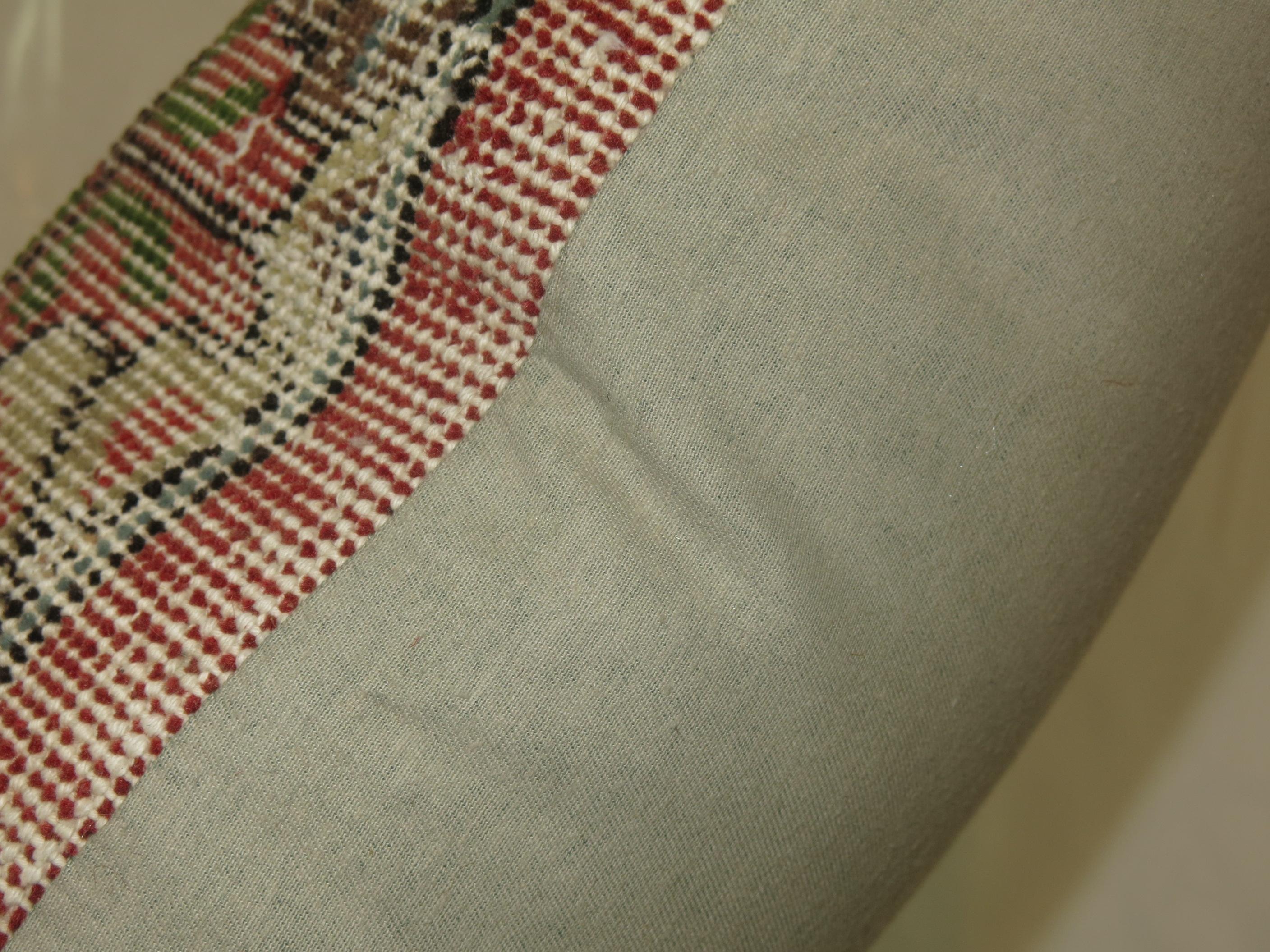 A large pillow made from a Turkish deco rug with a cotton back and zipper closure included.