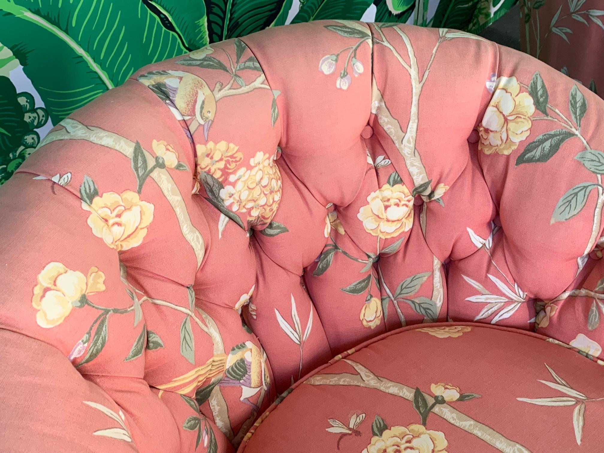 Pair of upholstered swivel club chairs in a vibrant floral motif. Very good condition with no stains or rips, only very slight fading along tops.