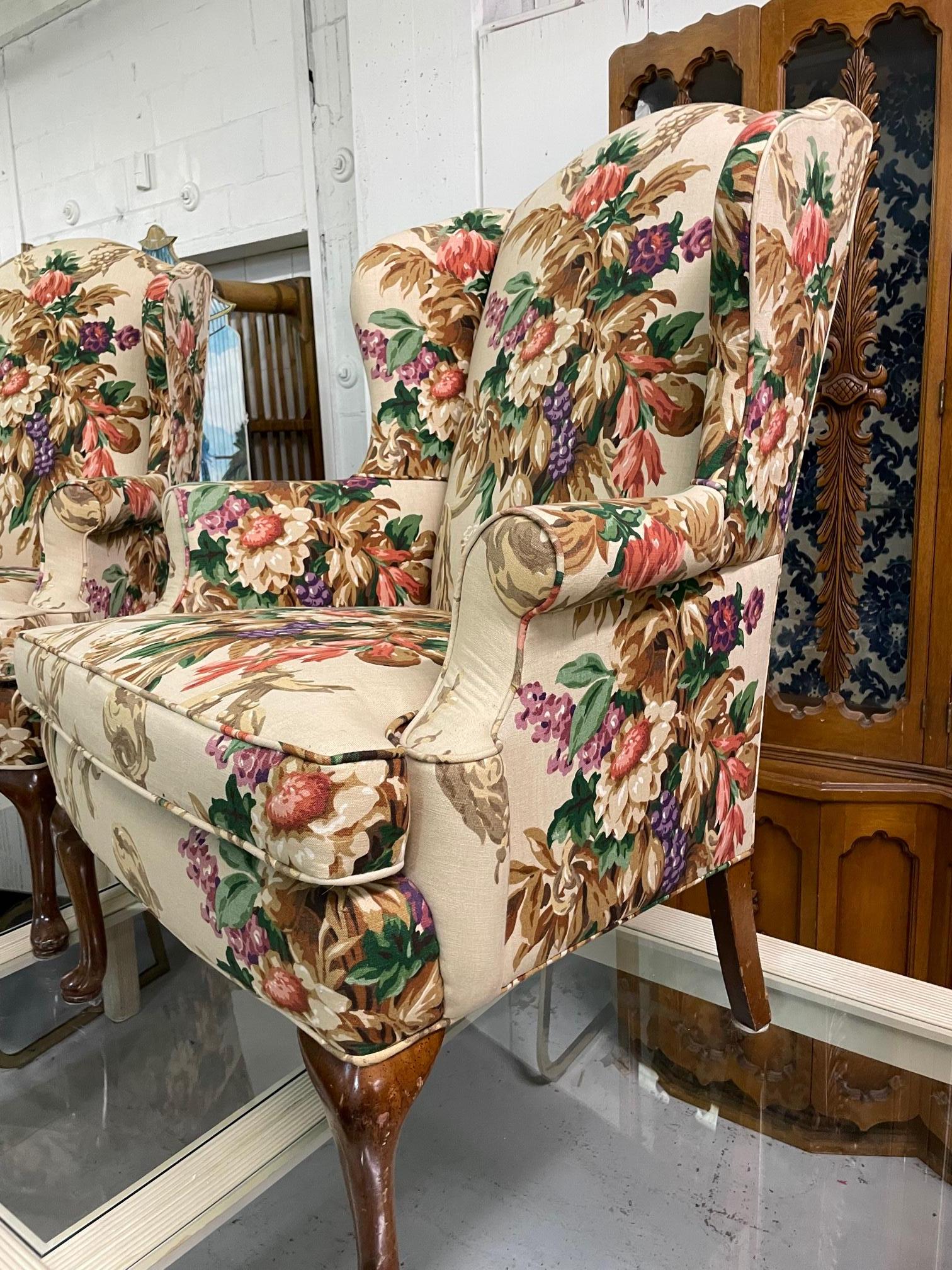 Pair of vintage wingback chairs upholstered in a colorful floral upholstery. Solid construction and only very minor imperfections consistent with age. No odors, stains or holes in fabric.
