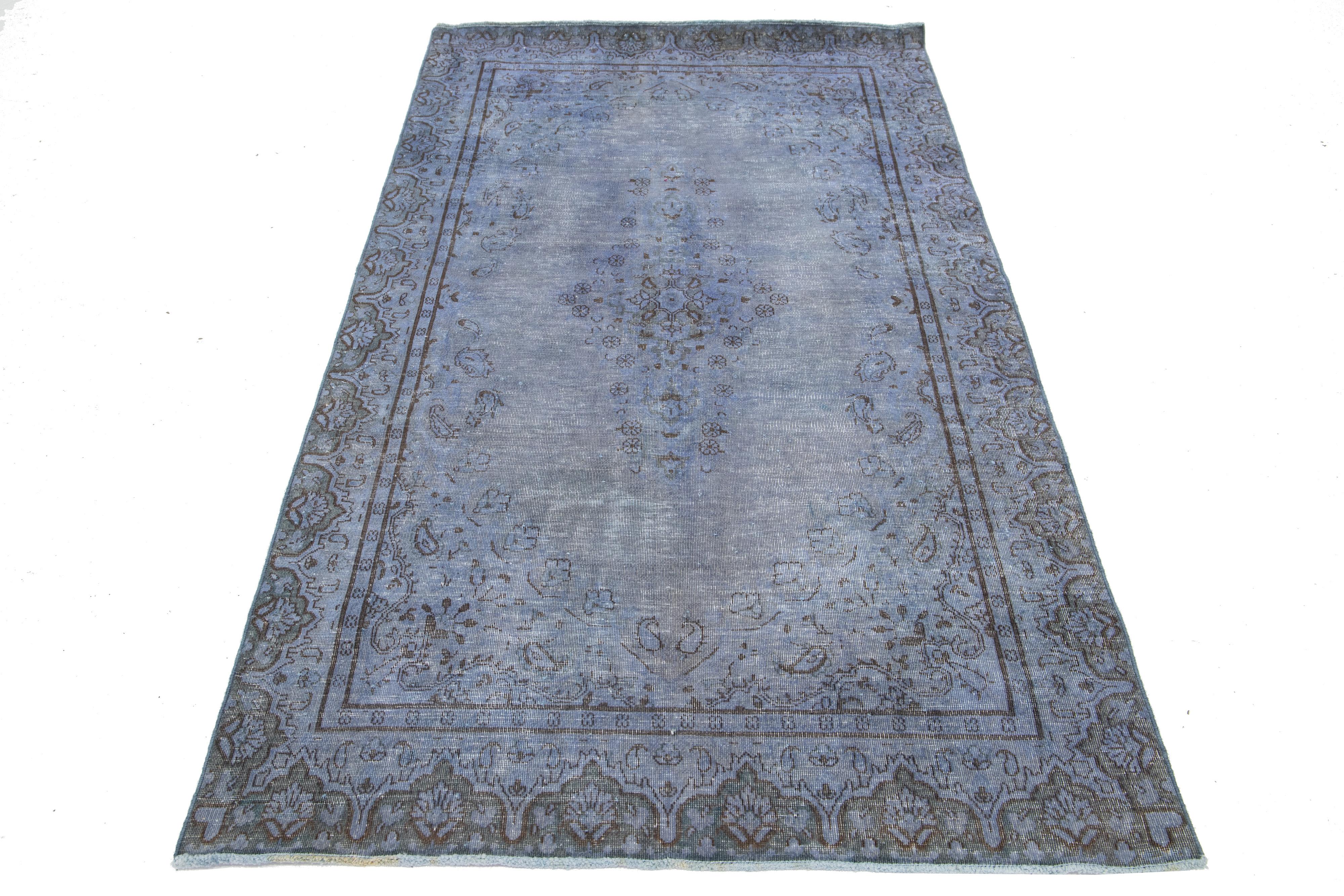 Questo tappeto vintage in lana persiana sovratinta vanta un accattivante campo grigio-blu ornato da affascinanti accenti floreali marroni.

Questo tappeto misura 3'6