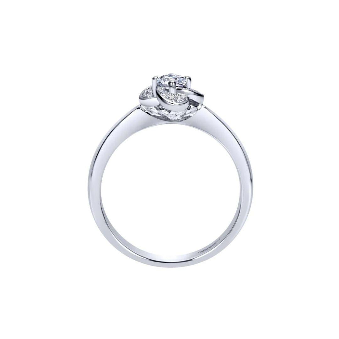 Ladies' Floral 14k White Gold Diamond Engagement Ring. Playful floral halo adds a romantic spin on this delicate setting. Center round diamond is included, 0.13 ct, G color, VS2 clarity. Side diamonds on the halo are 0.06 ctw, H color, SI clarity. 