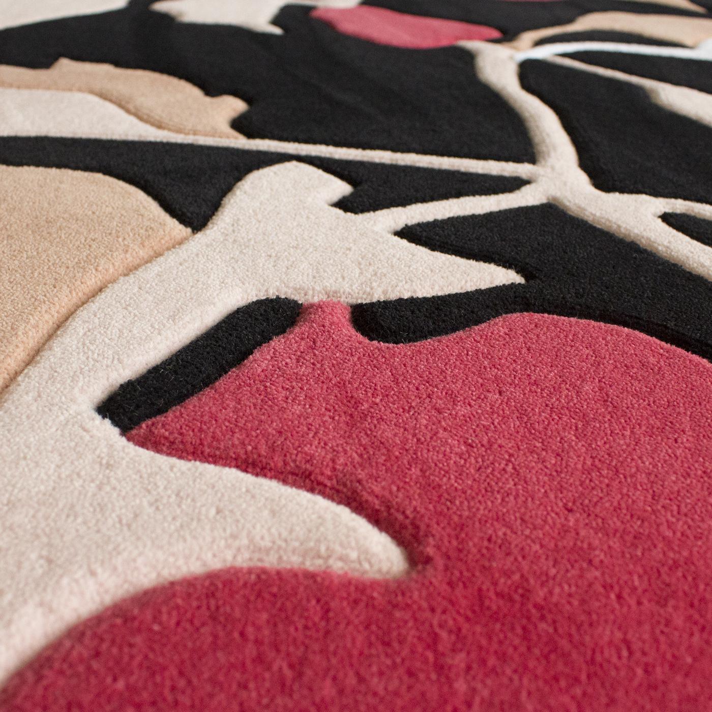 Designed from a drawing by Serena Confalonieri, this elegant round rug boasts a striking floral motif inspired by Japanese art in white, pink, and fuchsia enlivening a black background. This modern decorative piece is crafted entirely by expert
