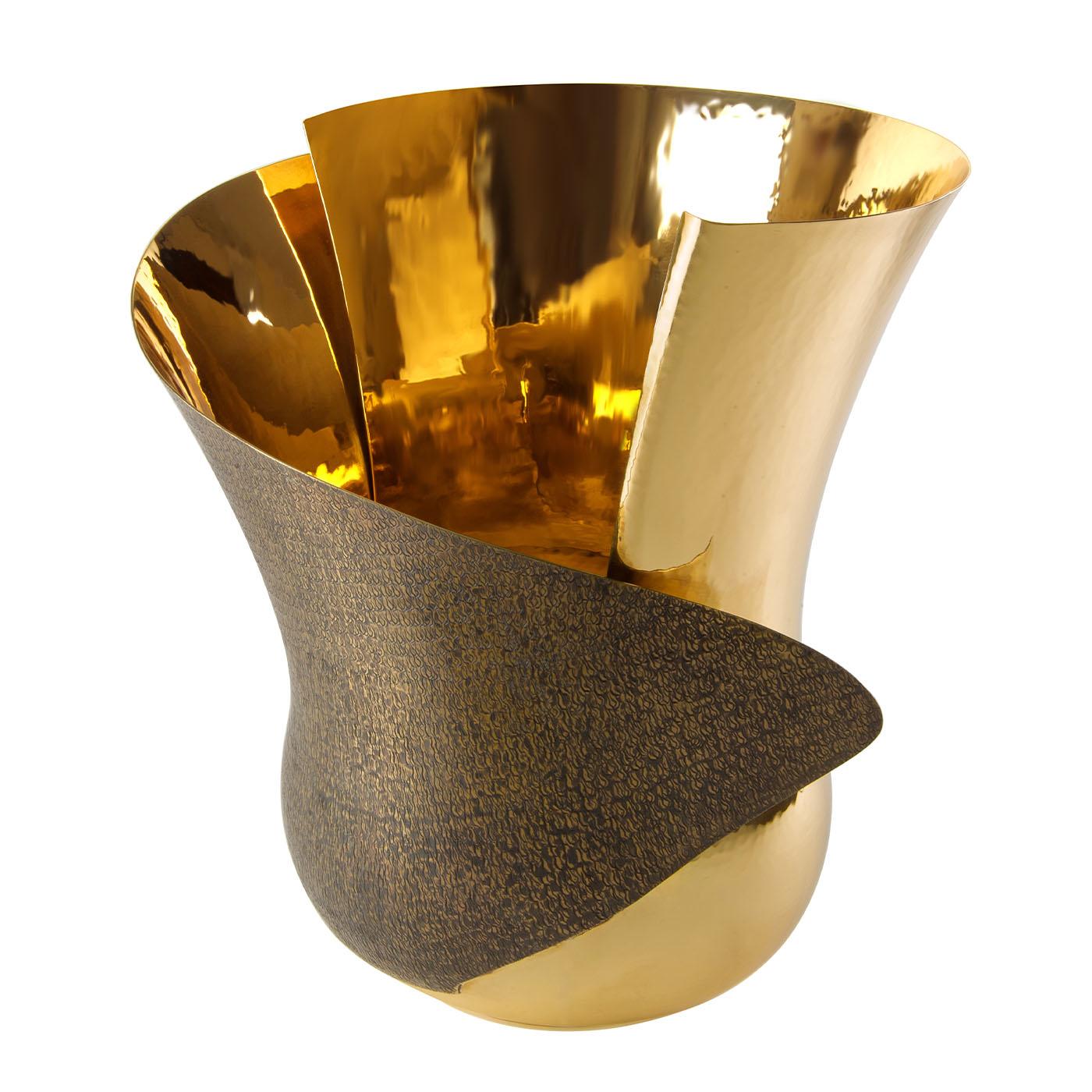 Inspired by a blossoming flower bud, this poetic and stunning brass vase is a collaboration with Riccardo Erata. A masterful hammering process is behind its luminous petals that, with their folding and bending design, deliver an intriguing sense of