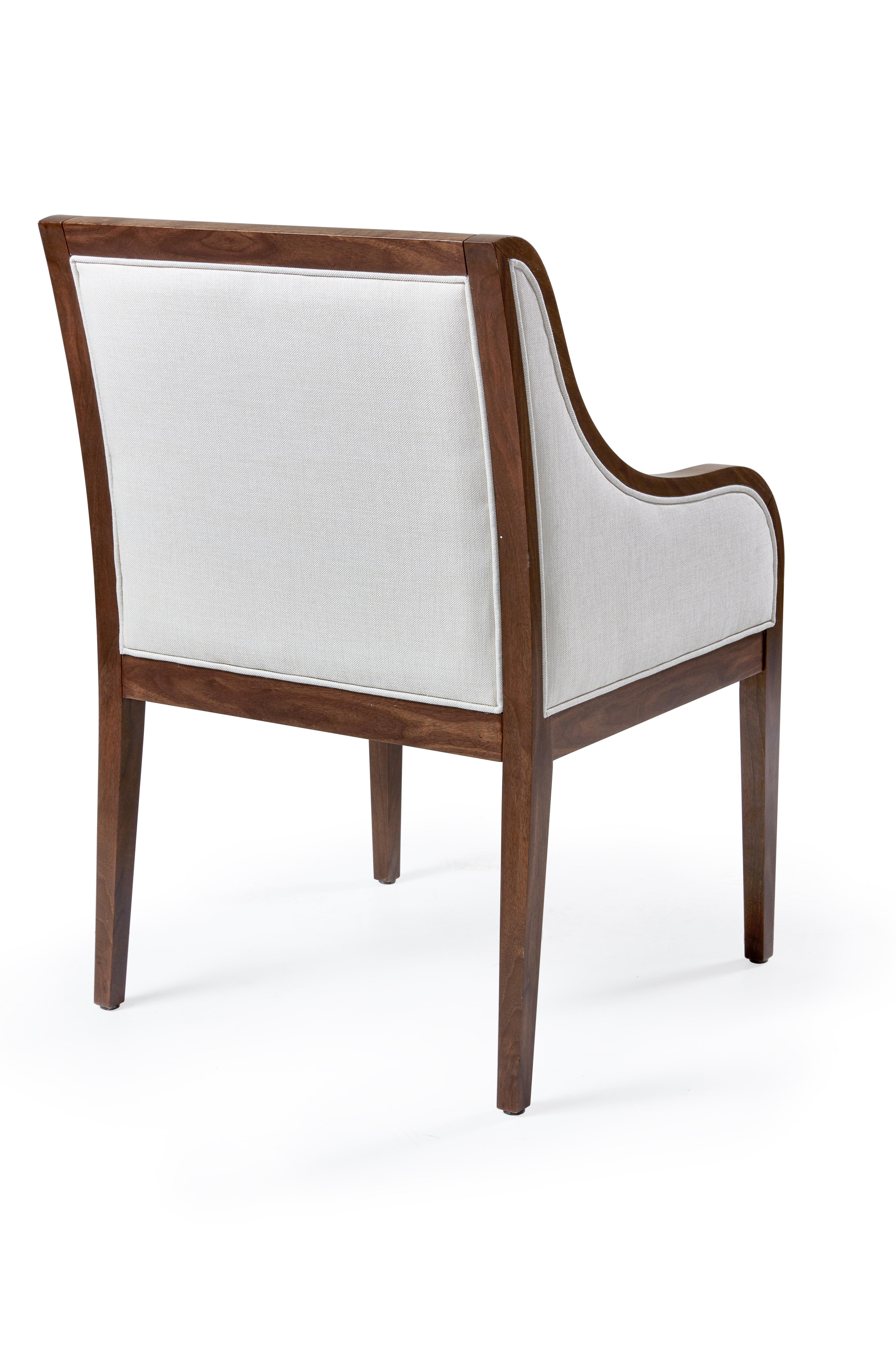 This well proportioned, deep seated chair has the perfect curved arms to assure comfort through long dinner parties or even at a desk. Fully upholstered and framed in wood, the elegant lines allow this chair to dress up any space.
