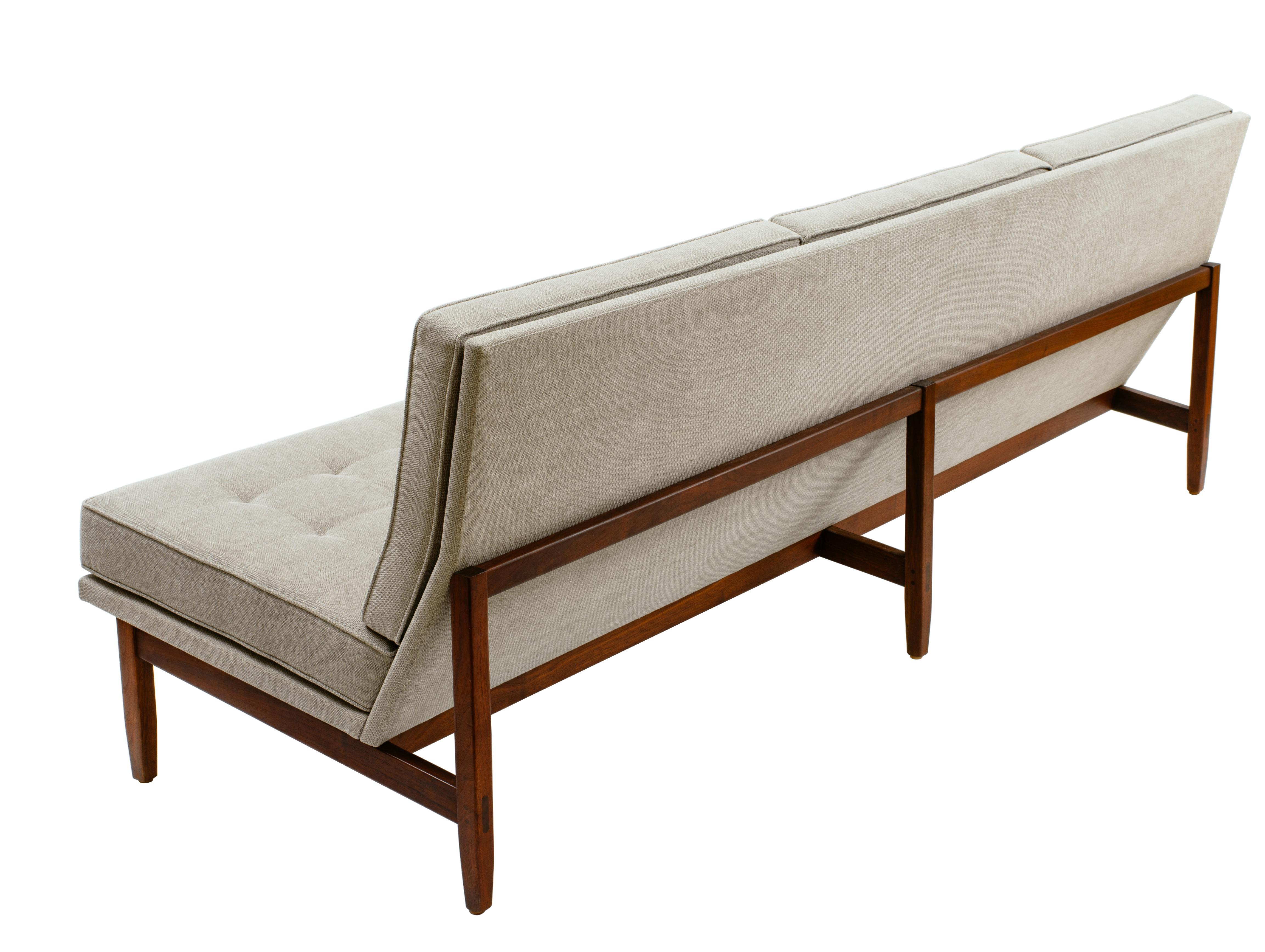 1960s Florence Knoll armless sofa with blind tufted cushions and a solid walnut frame that features mortise and pegged tenon construction to the rear legs. Beautiful, angular form, fully restored as original.