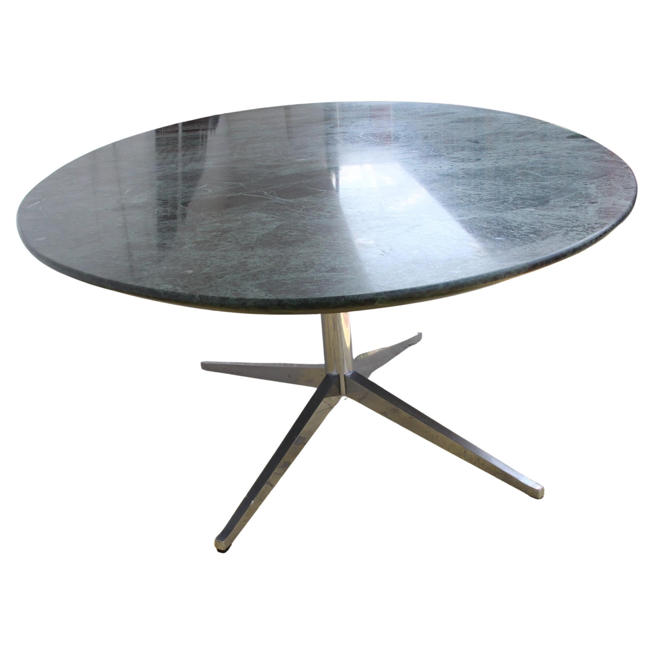 Cette table peut servir de table à manger ou de table de conférence. Il est conçu par Florence Knoll et fabriqué par Knoll Furniture. La table est dotée d'un grand plateau ovale en granit noir très veiné et d'un piètement en acier à quatre branches.