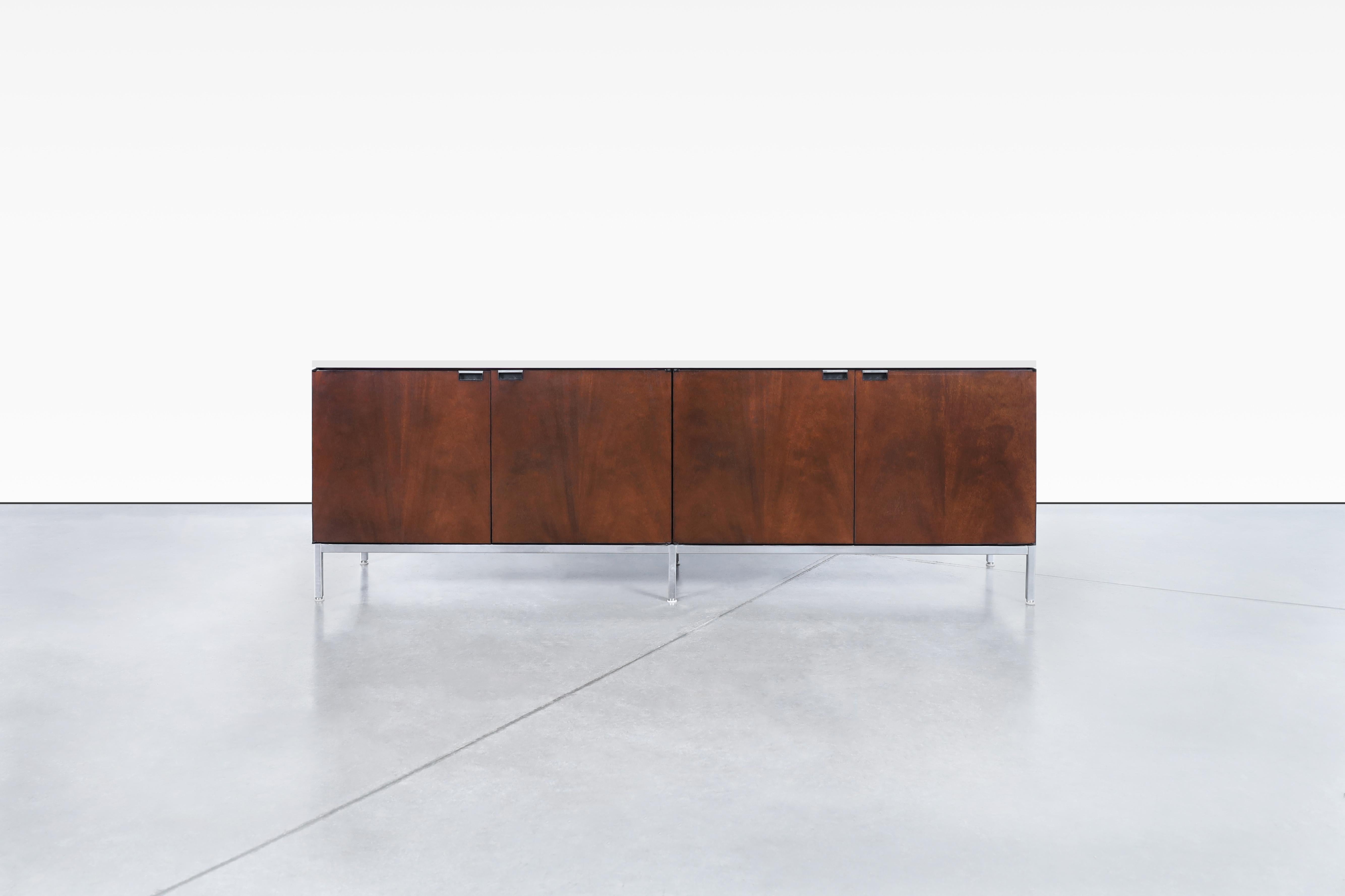 This beautiful credenza designed by Florence Knoll is not only stylish and functional, but it also comes engraved with the designer's name, making it a true collector's item. The warm mahogany tone cabinet complements the Carrara marble beautifully