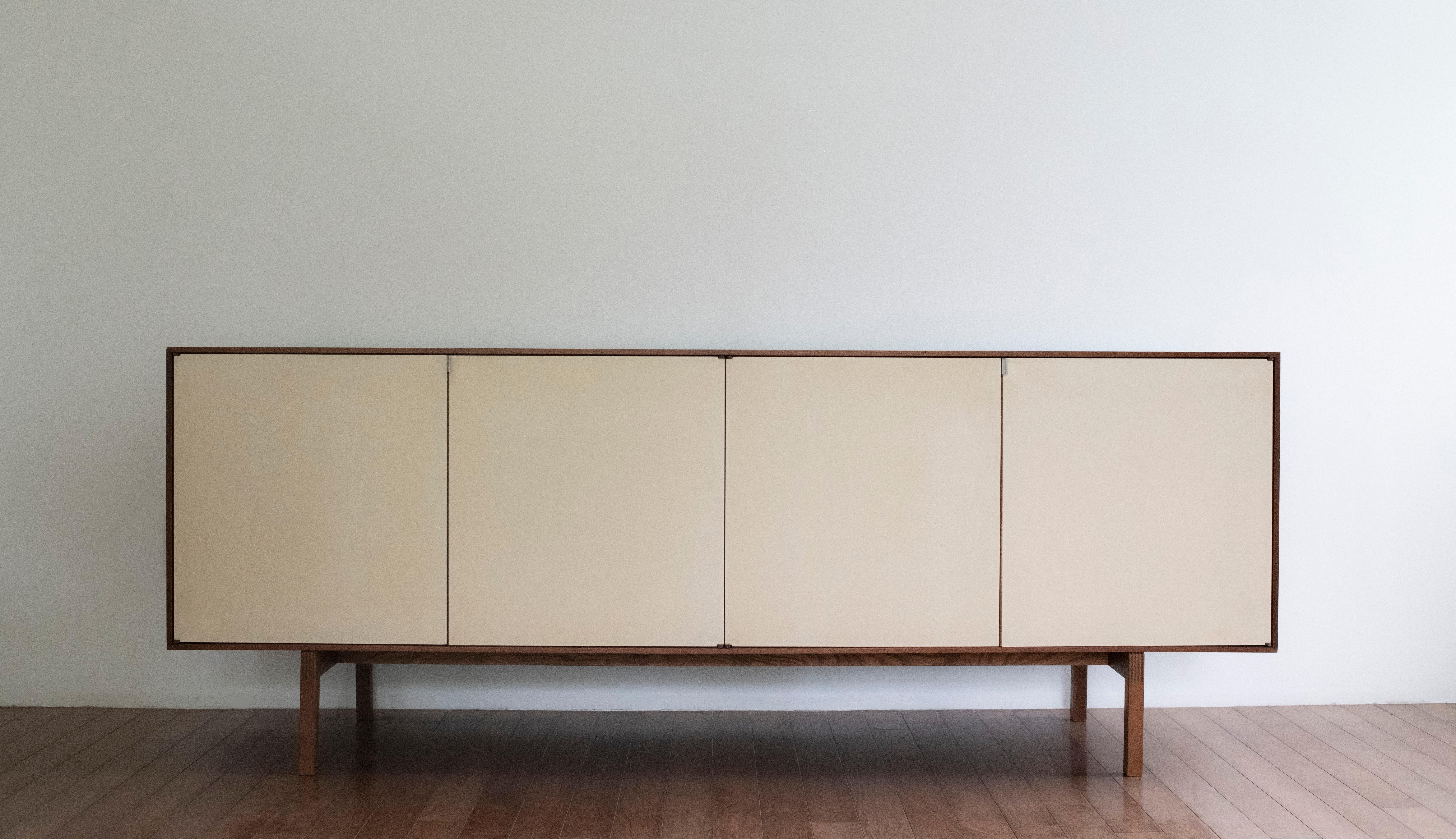 Early Florence Knoll designed credenza. Beautiful and well made credenza in walnut with lacquered doors. Credenza is complete with original drawers, two large shelves and two smaller shelves.