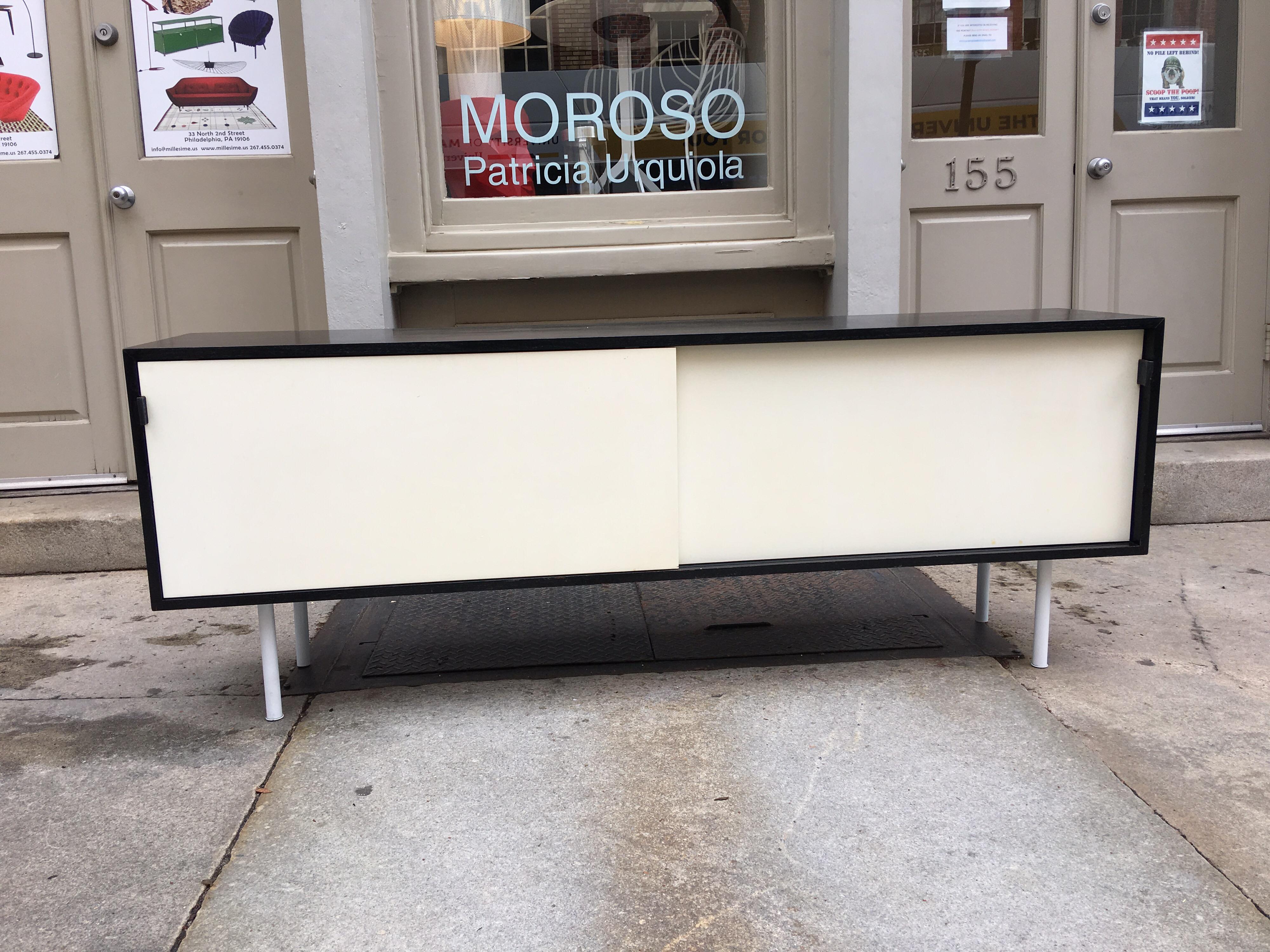 Florence Knoll original black finish credenza. Use either on the wall or with legs, original cleat is still installed for ease of mounting on the wall. Inside white finish shows some discoloration. Original label to underside.