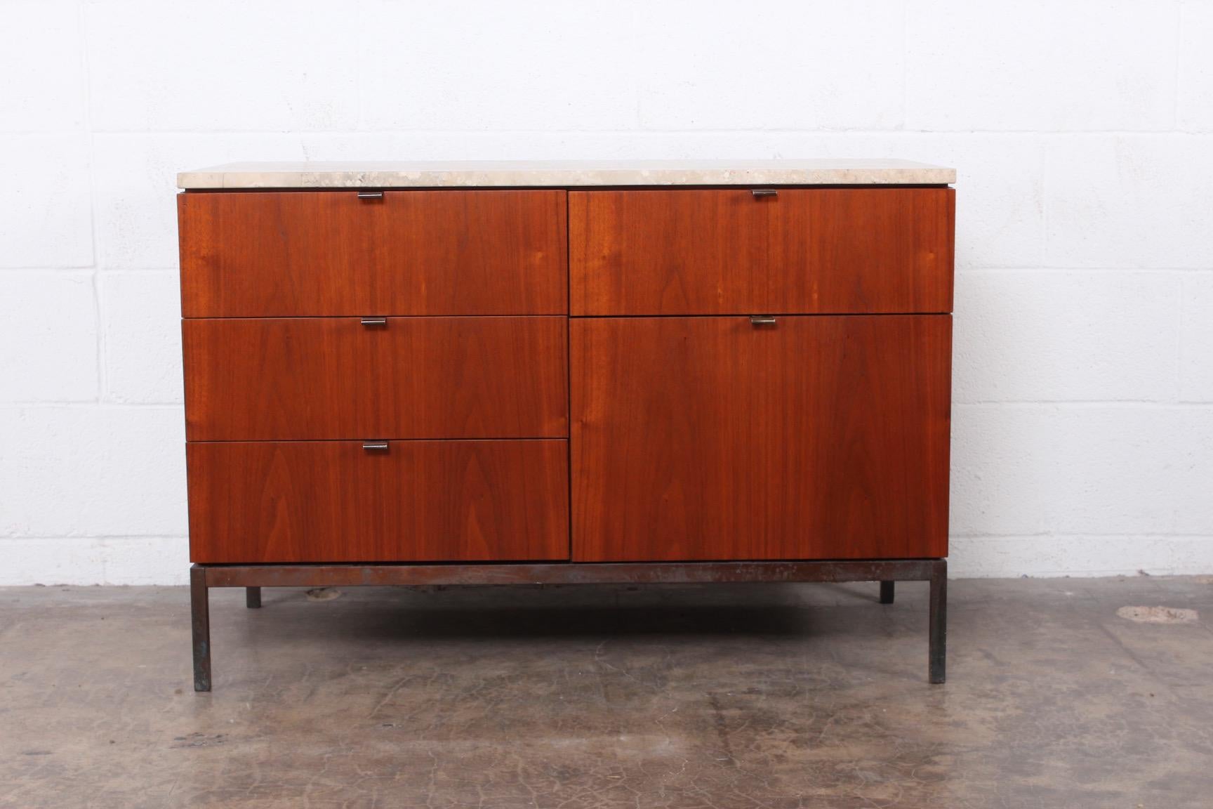 A walnut credenza with bronze base/hardware and travertine top. Designed by Florence Knoll for Knoll.
